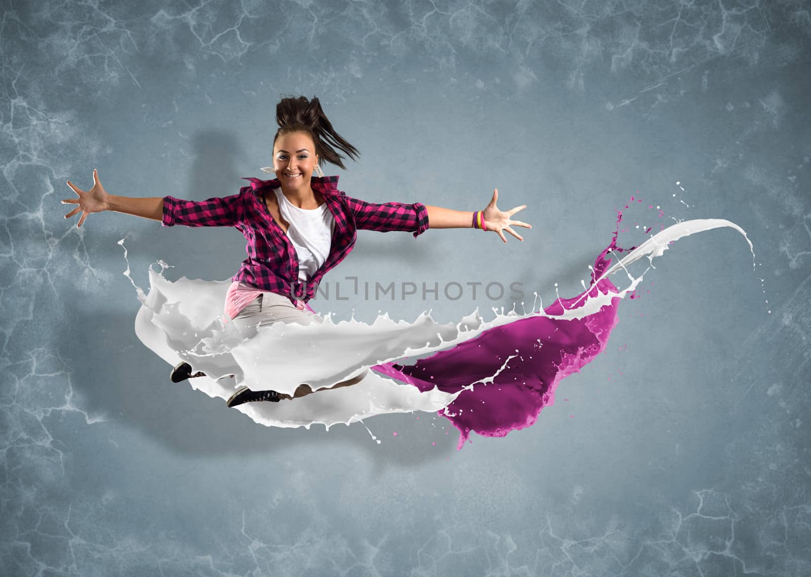 female dancer jumped surrounded by splashes of paint