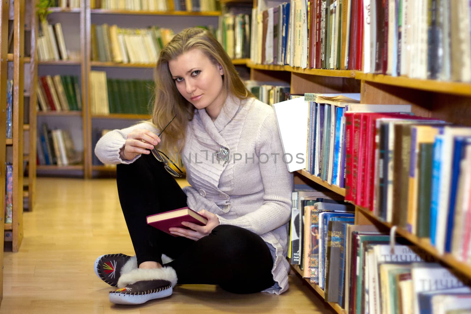 Girl sitting on floor in the old library by victosha