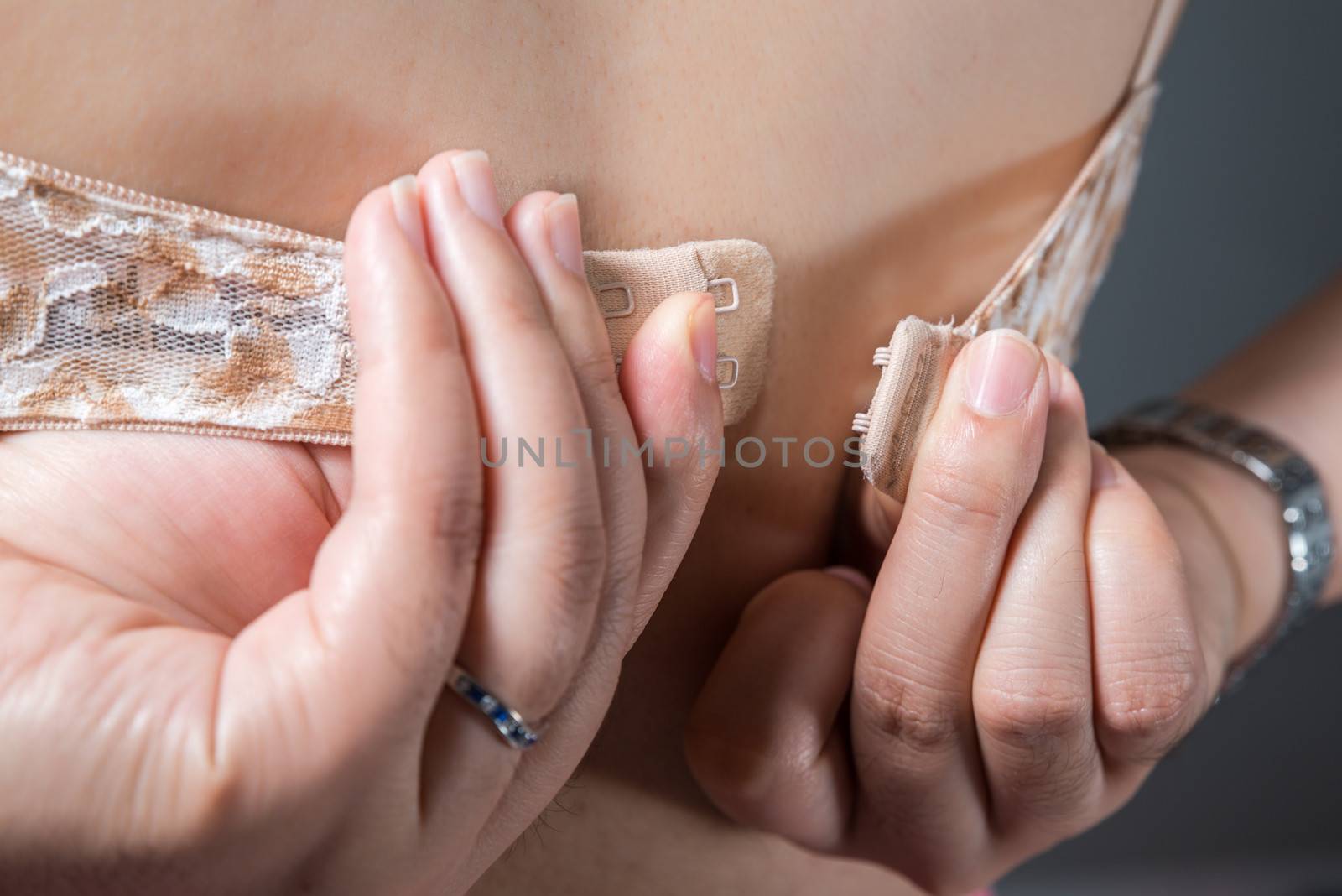 Woman taking off her bra with both hands