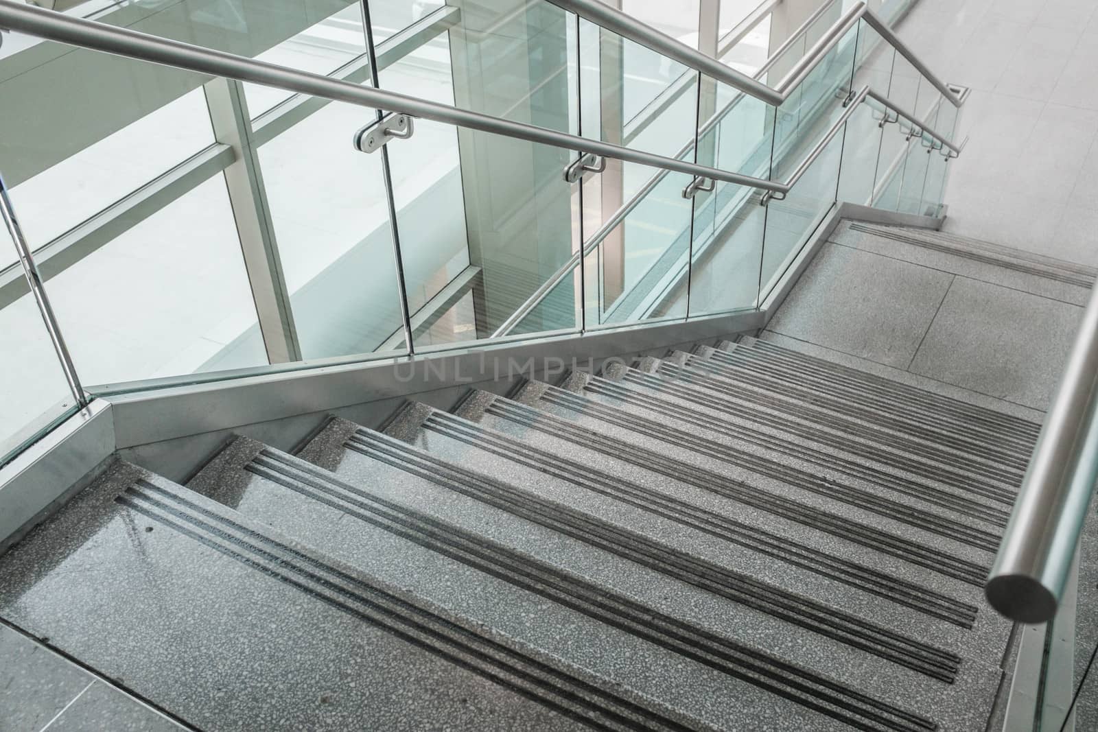 Pattern of several steps of granite stairs with glass railing