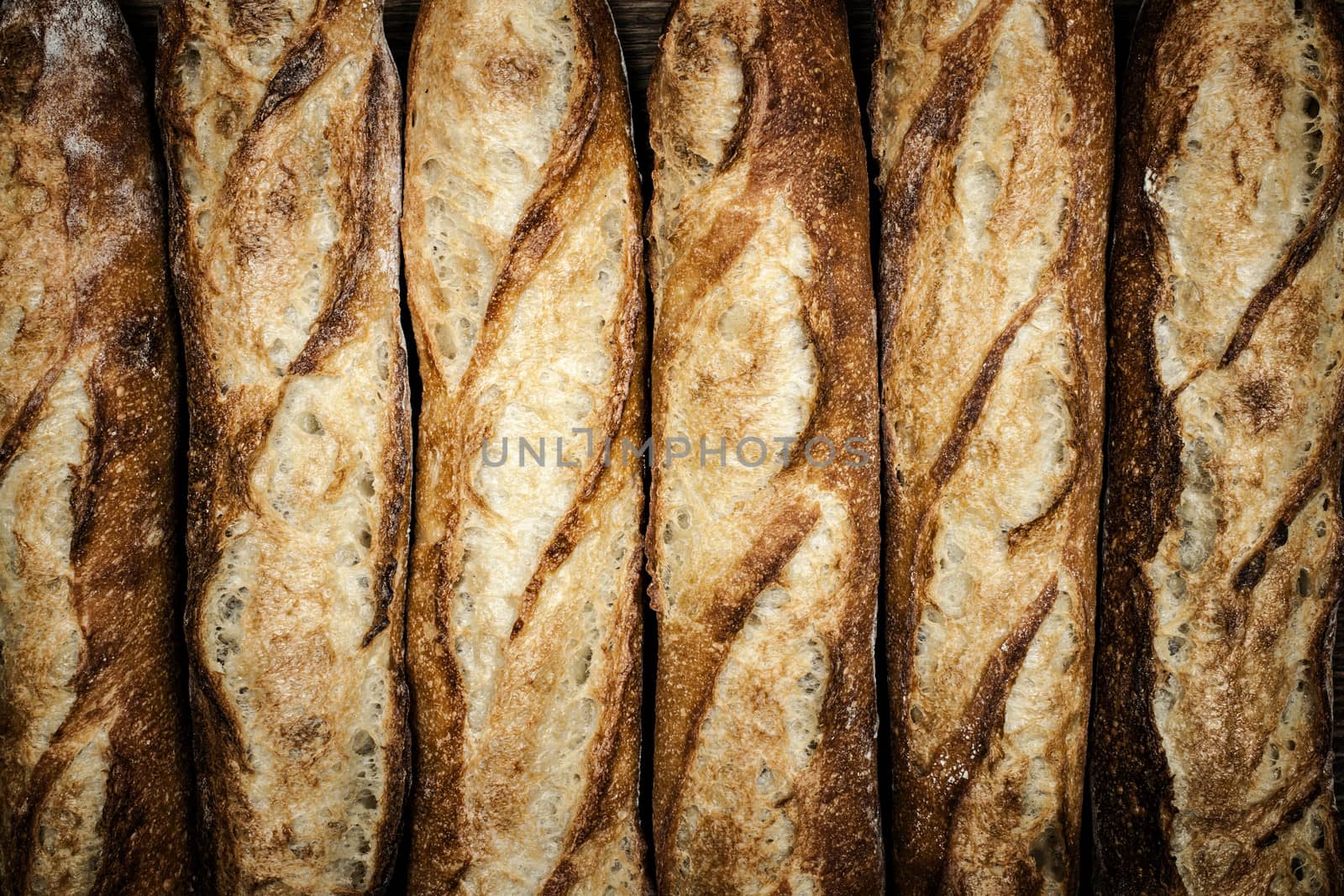 Fresh artisan baguette bread loaves in a row