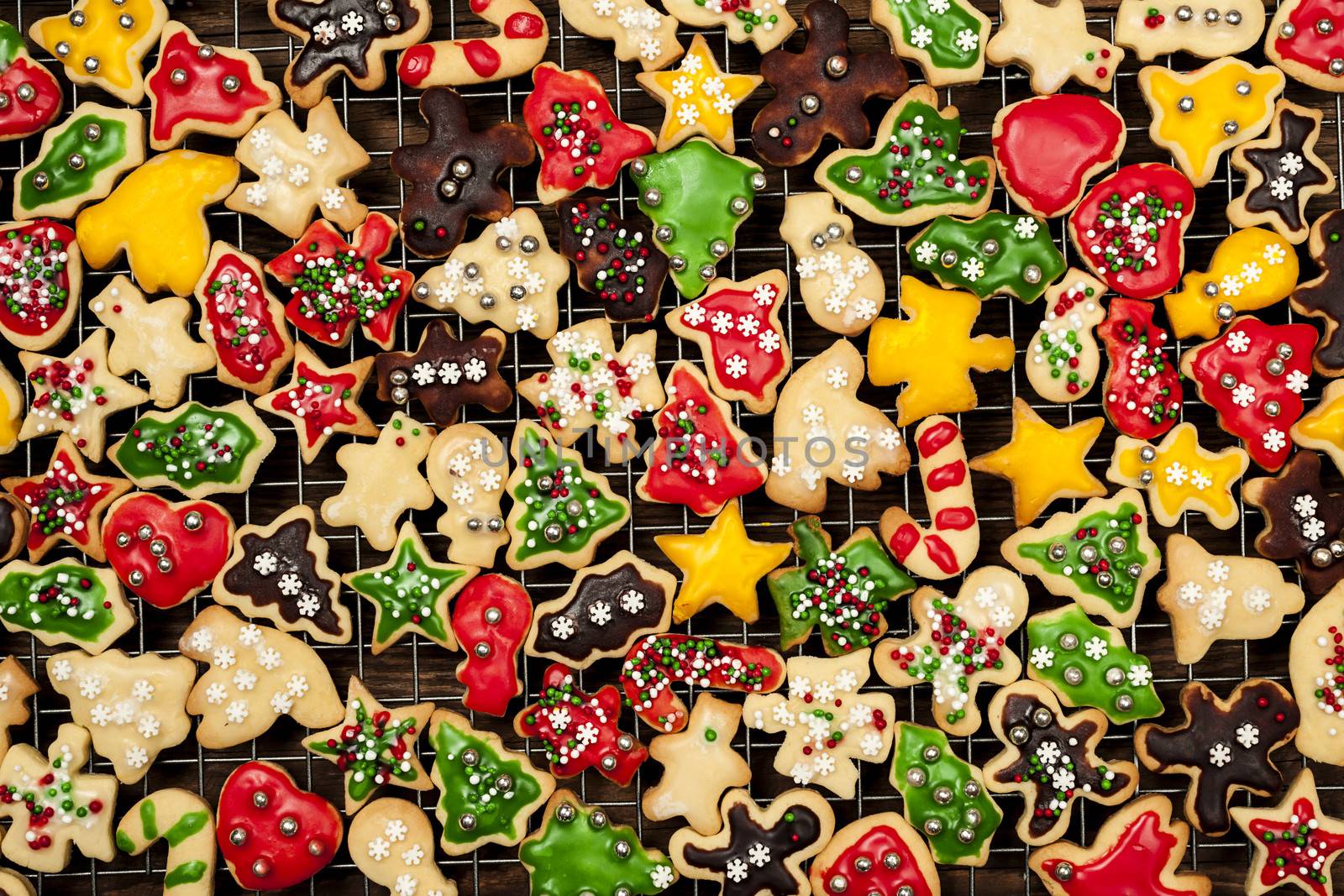 Cooling rack with freshly baked homemade shortbread Christmas cookies over wooden background from above