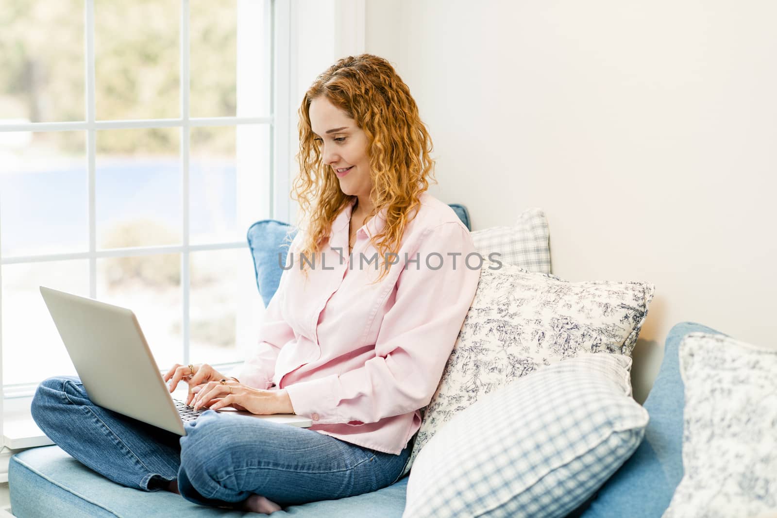 Caucasian woman using laptop computer sitting on couch at home