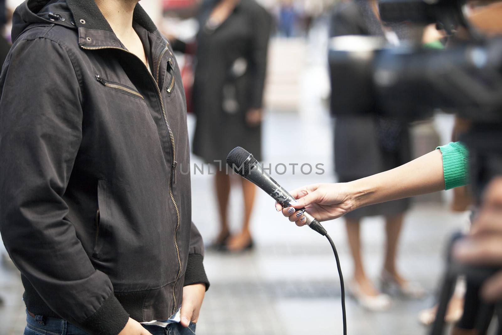 A journalist is making a interview with a microphone