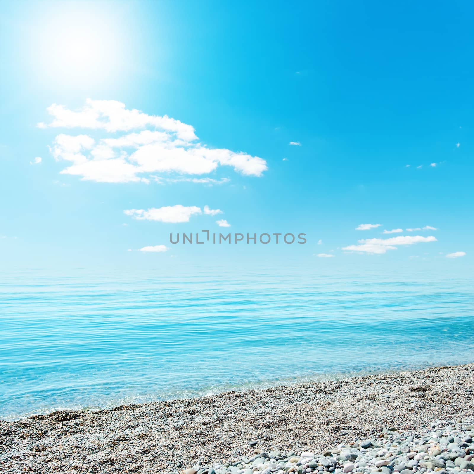 sun in blue sky over sea