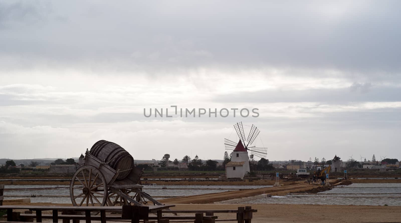 Old windmill on the salines near trapani with lake and bridge