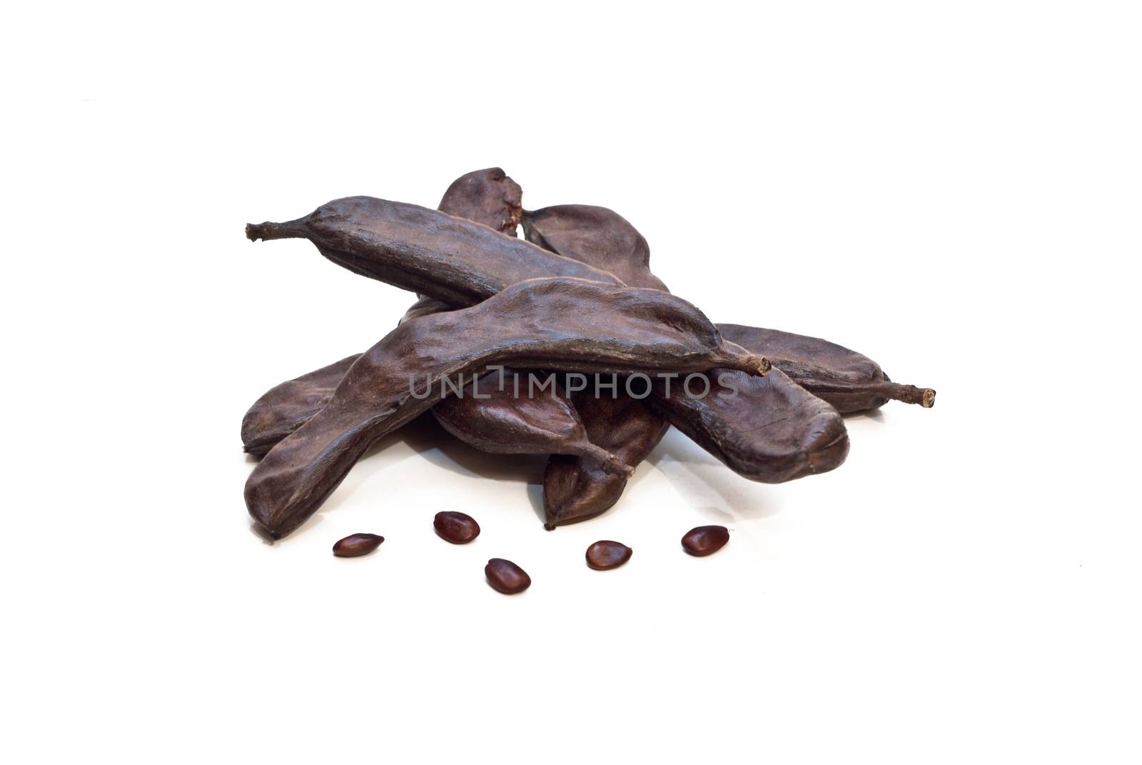 Carrubba and carat seeds isolated on white background