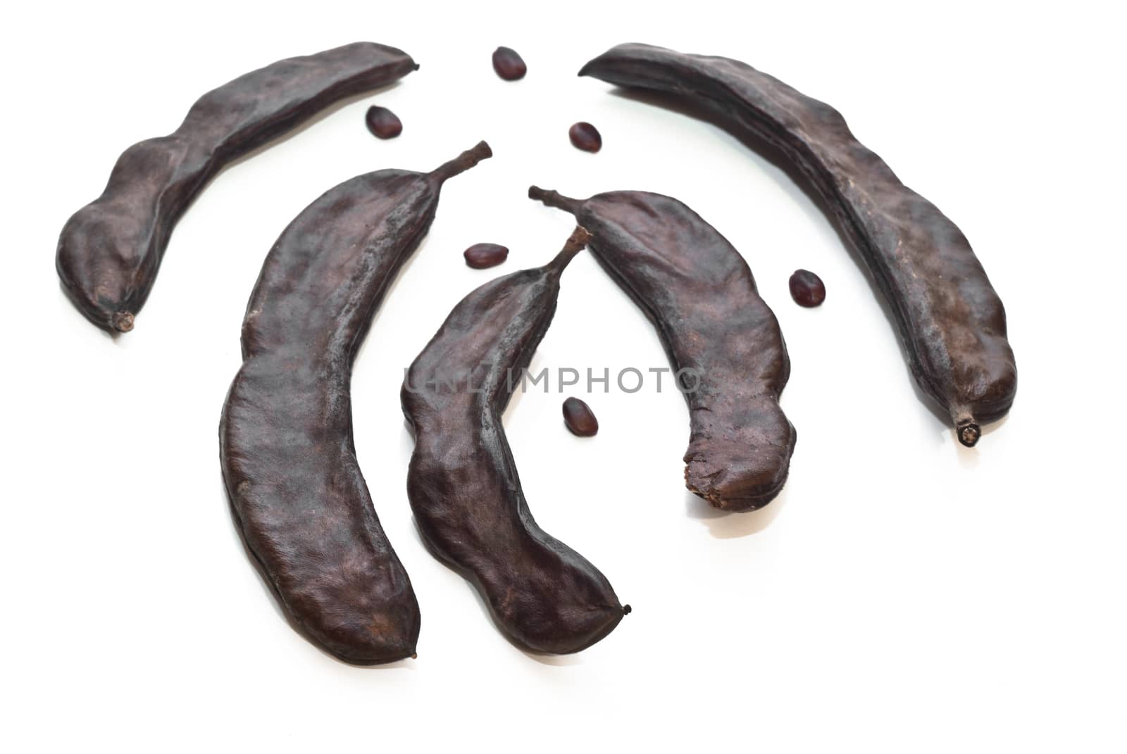 Carrubba and carat seeds isolated on white background