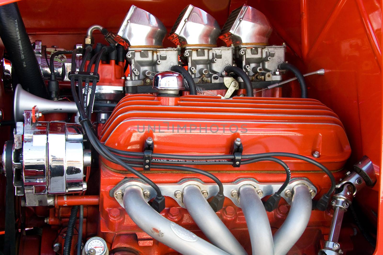 Details of 4 cylinder petrol engine painted red / orange.