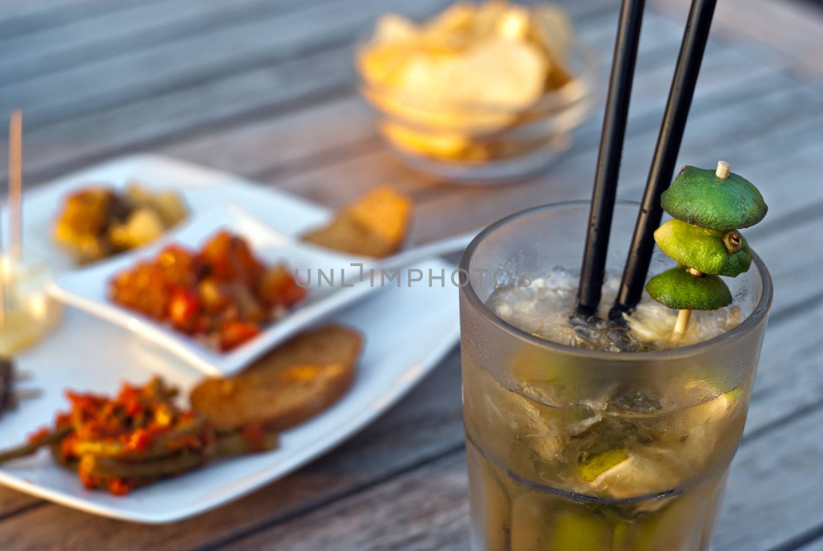 Mojito served in a glass with crushed ice and lime on wooden table