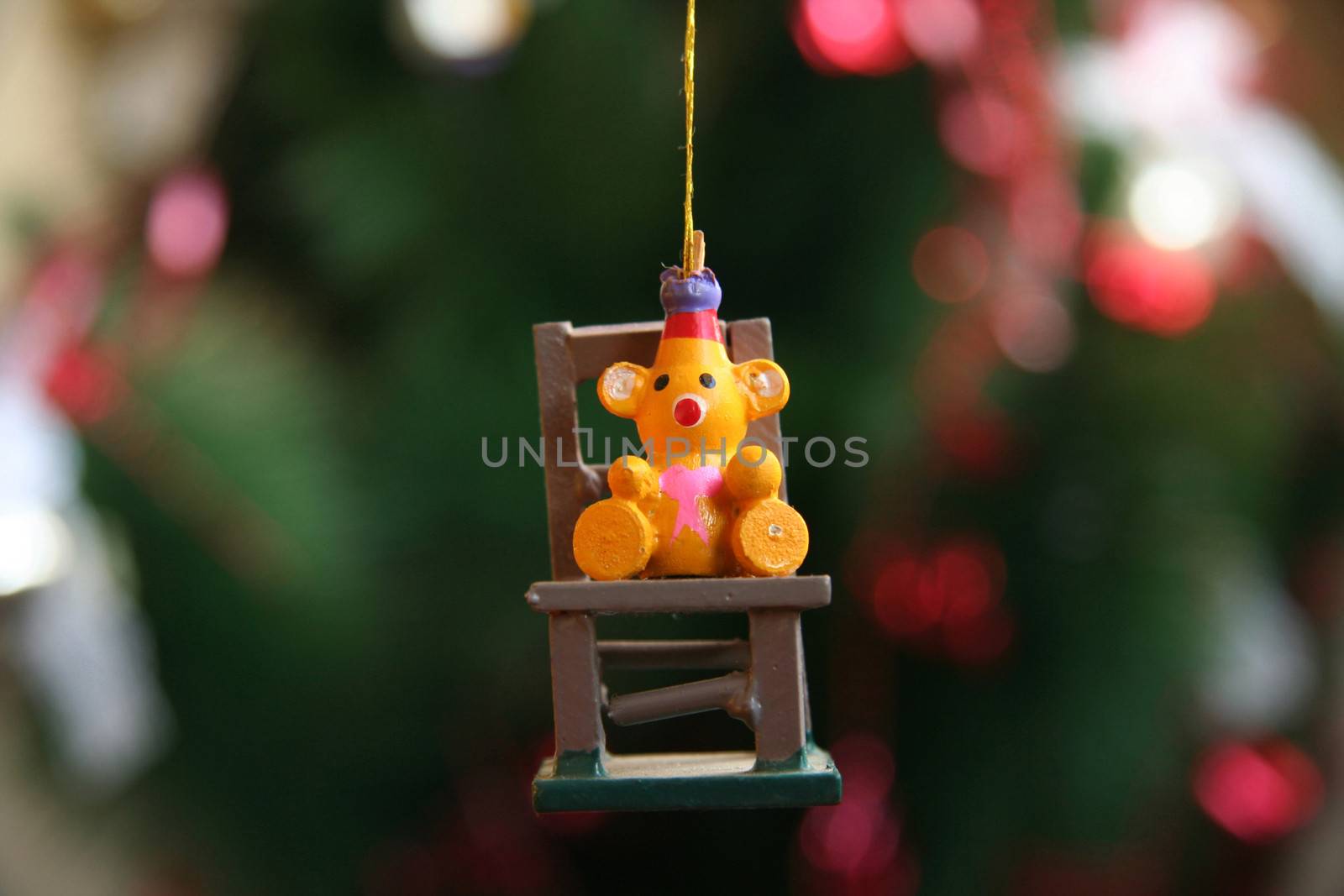 Close-up of a bear shaped Christmas ornament hanging from a golden string