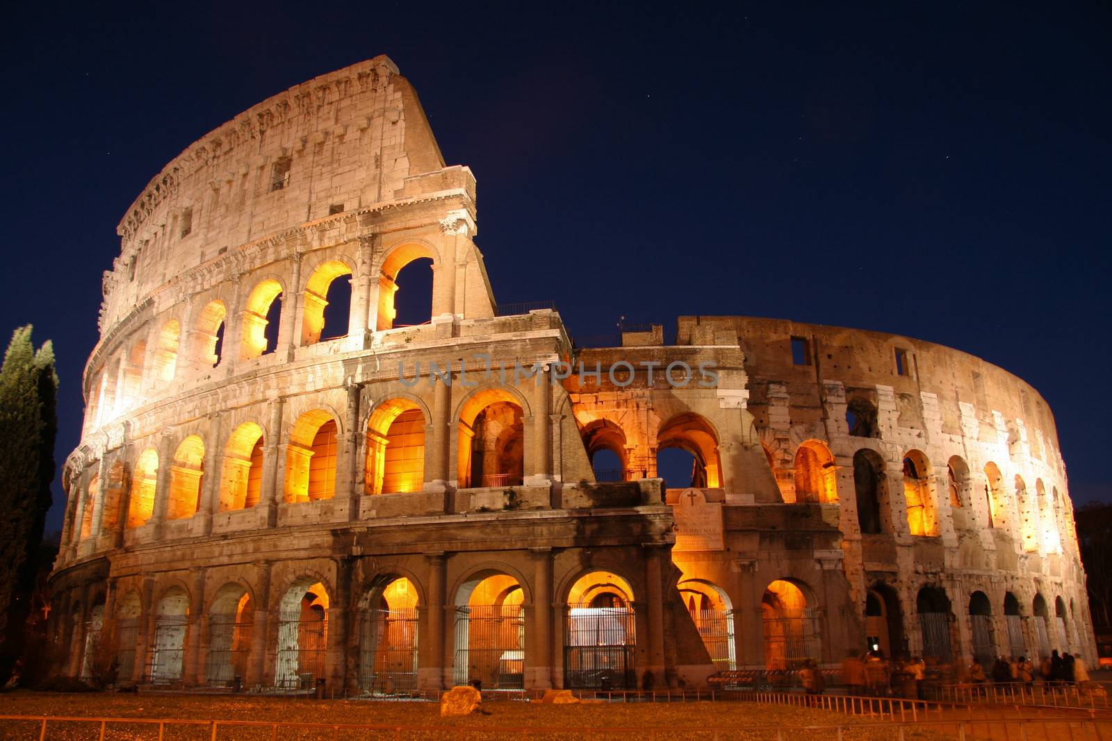 Exterior of Coliseum in Rome illuminated at night, Italy.