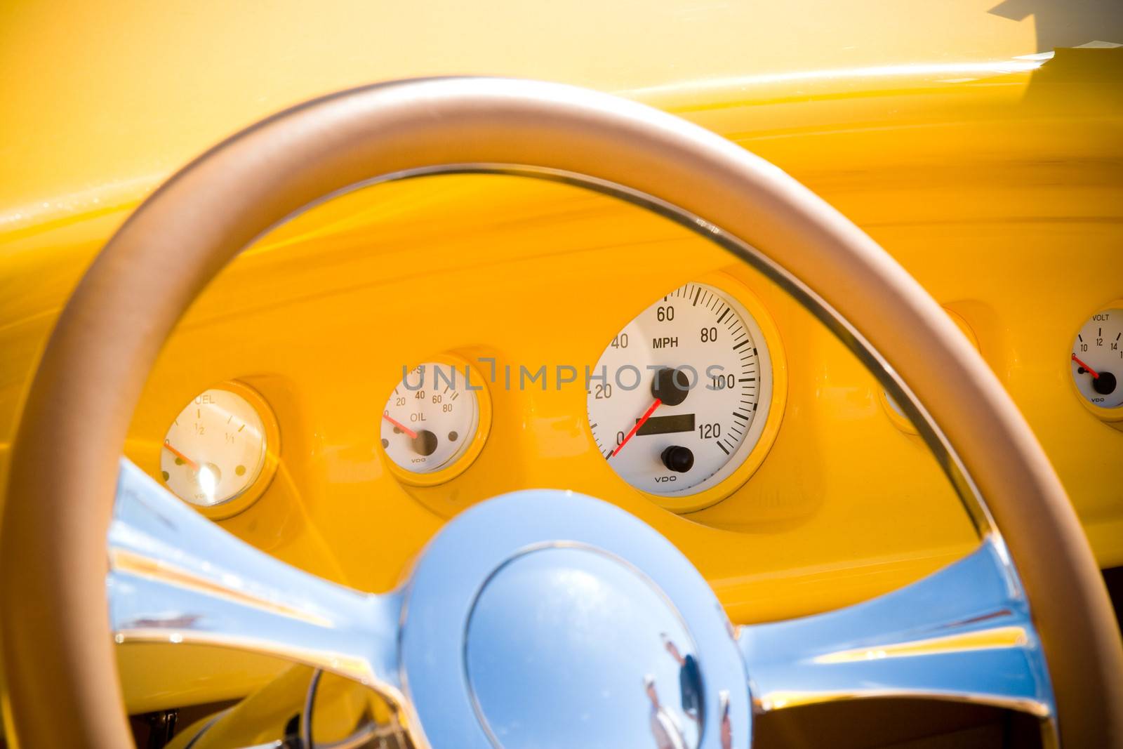 The dashboard and the steering wheel of a refurbished antique car.