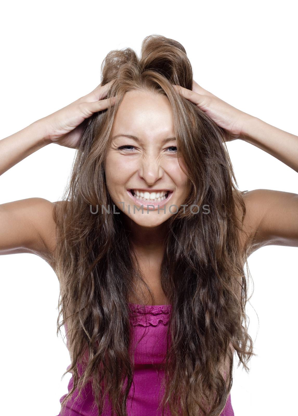 young woman running fingers through her hair making a face