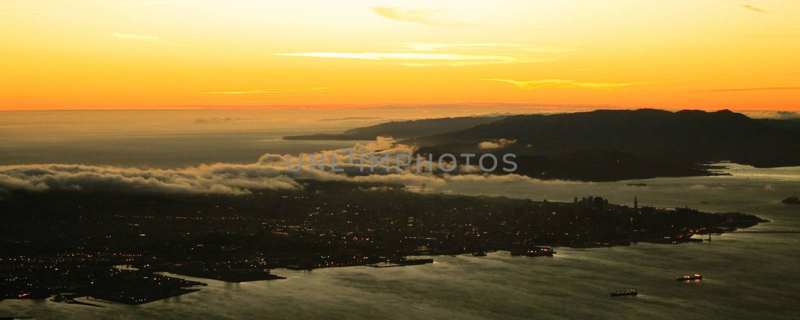 An aerial shot from the Golden Gate bridge and the San Francisco city at sunset.