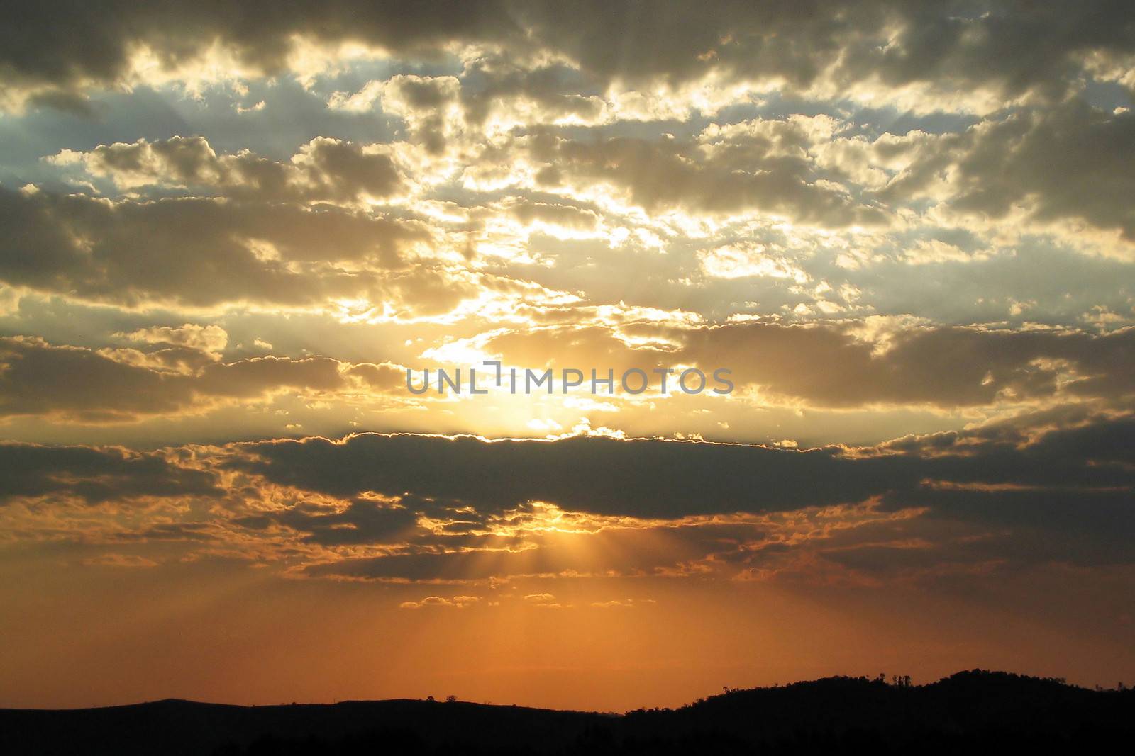 Golden sunset with rays shining through the clouds.