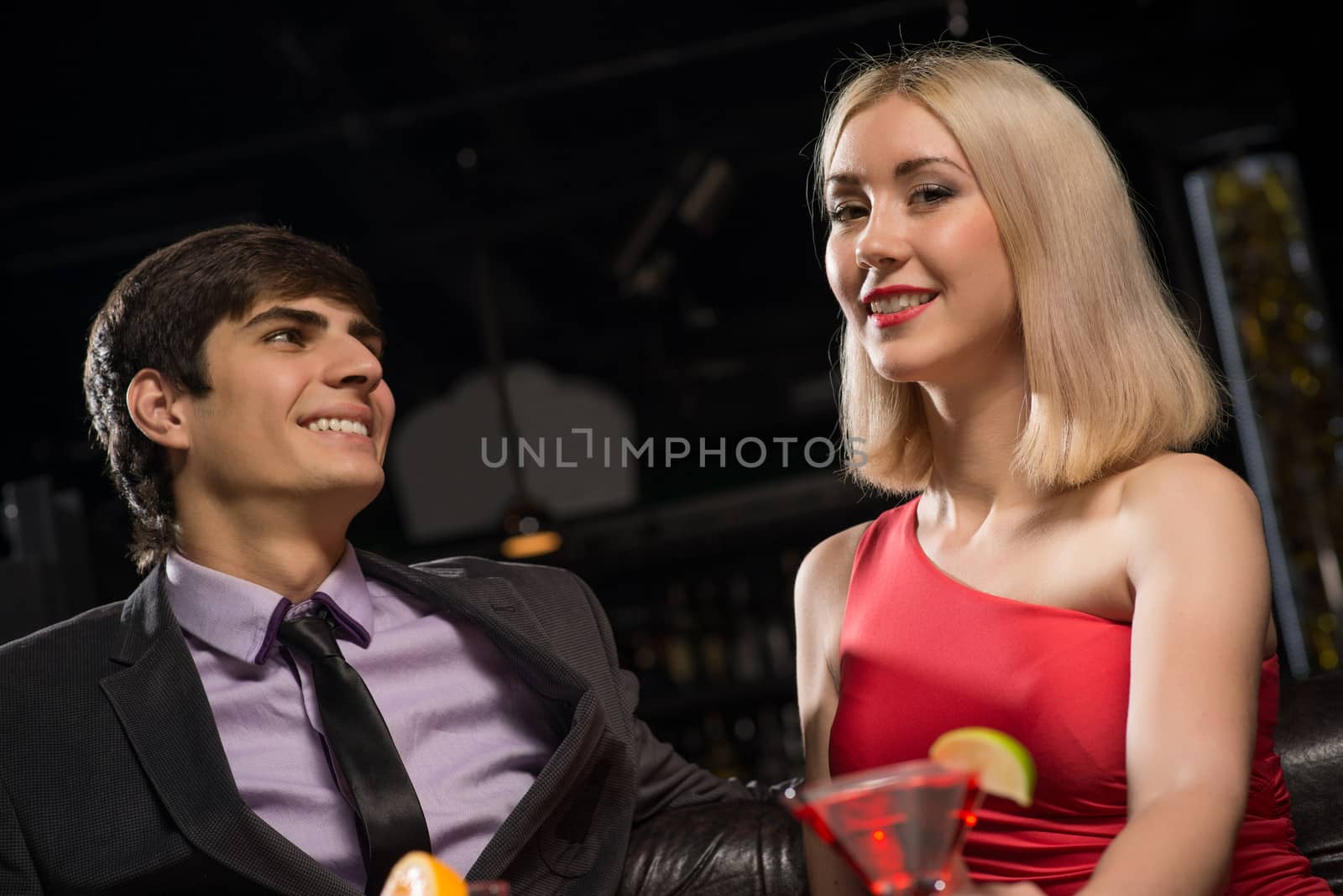 Young couple talking in a nightclub, have fun