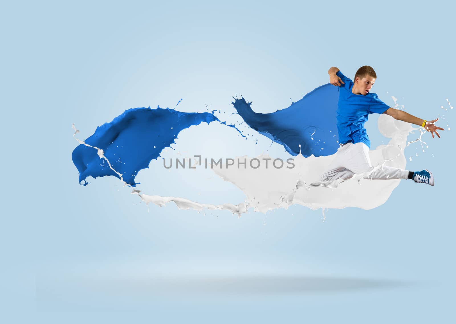 young male dancer jumping surrounded by splashes of paint