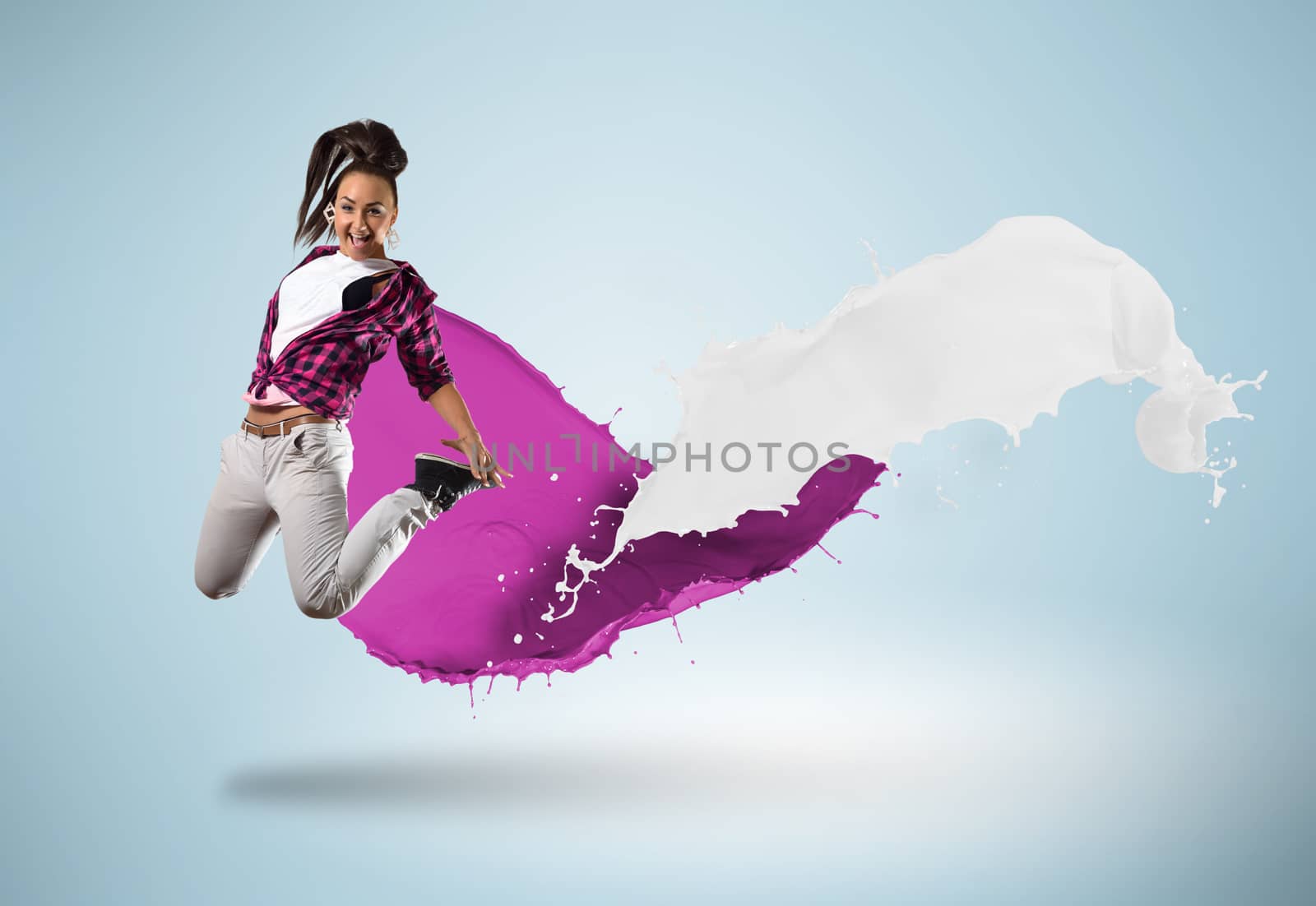 young female dancer jumping surrounded by splashes of paint