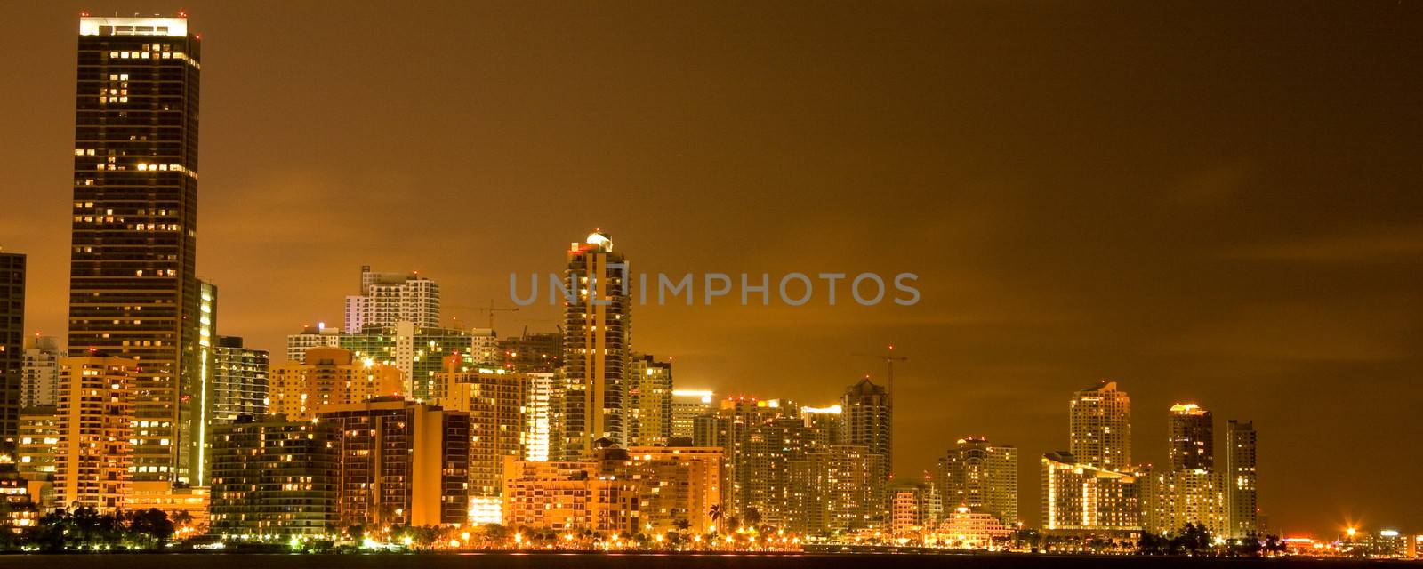 Illuminated commercial buildings at night in downtown Miami, USA.