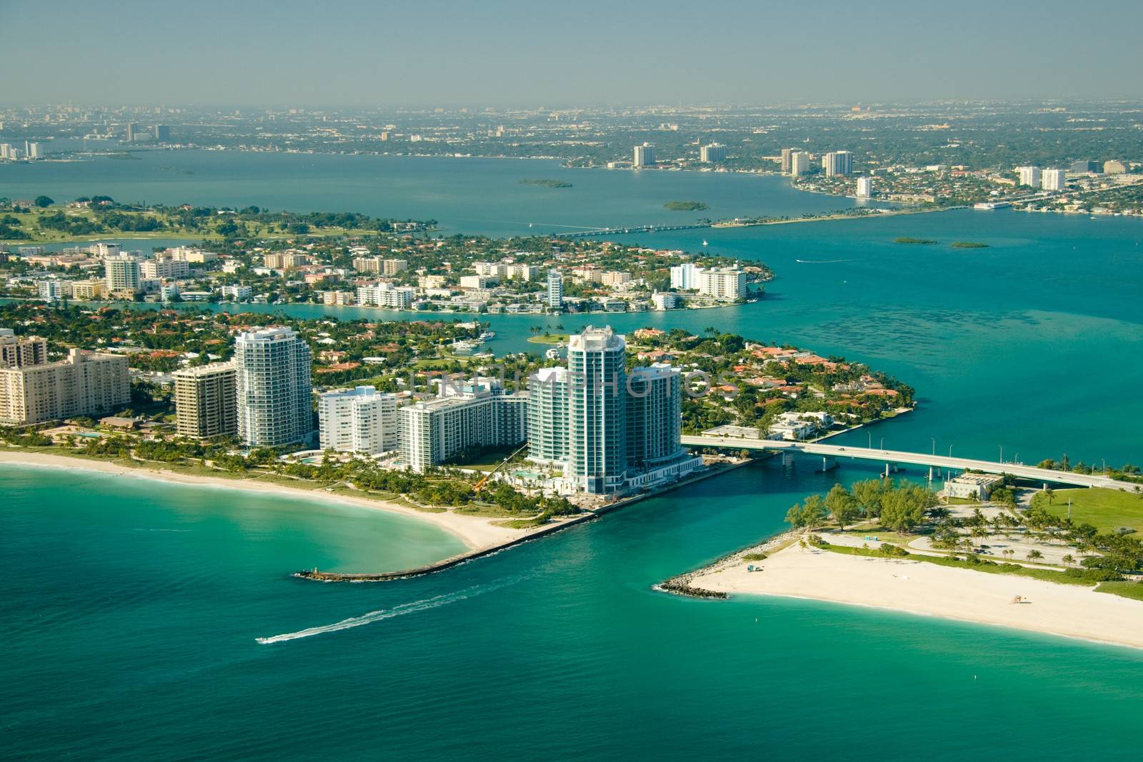 An aerial view of the seashore in Miami with deep green and blue waters.