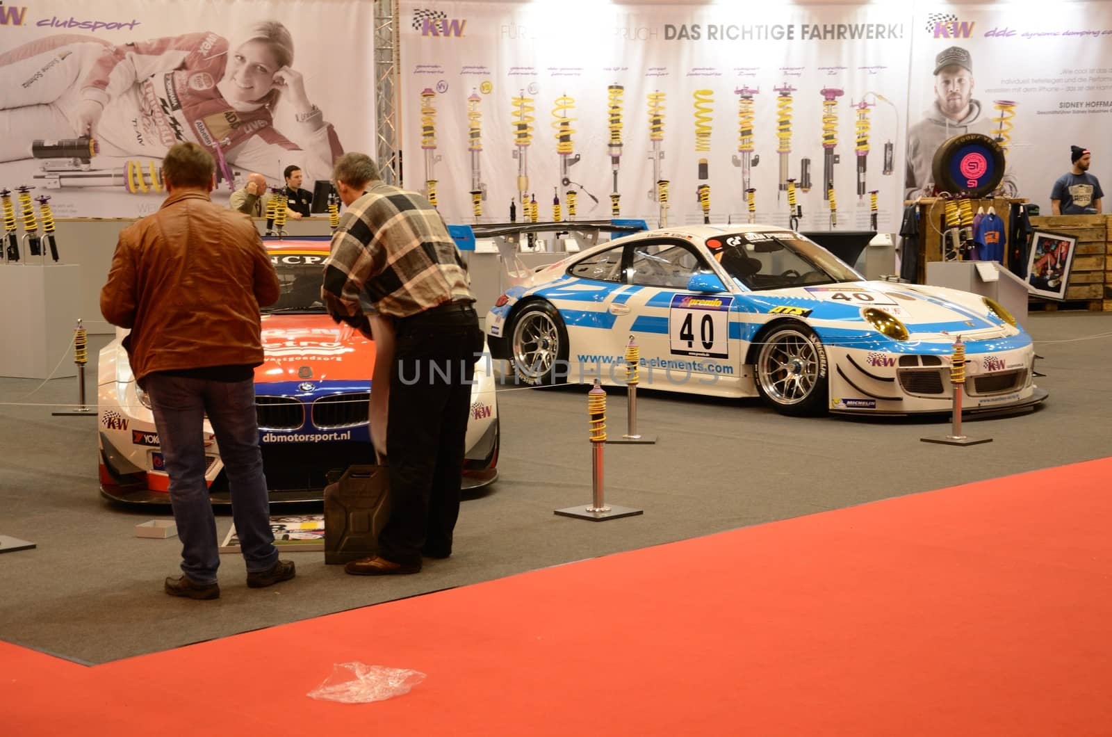 ESSEN, GERMANY - December 2: Visitors admire tunned cars BMW and Porsche during Essen Motor Show in Germany, on December 2, 2013.