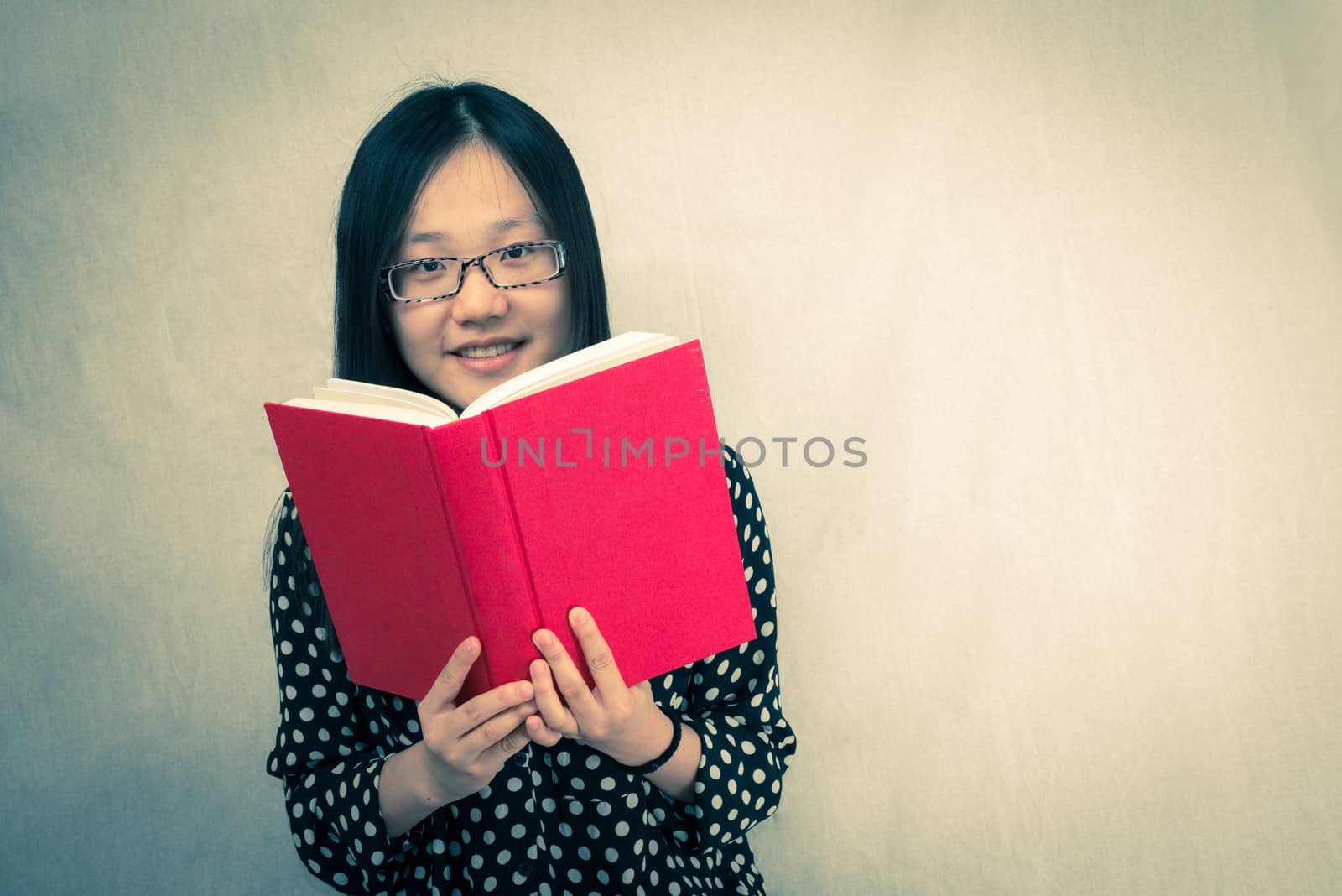 Girl reading a red book by IVYPHOTOS
