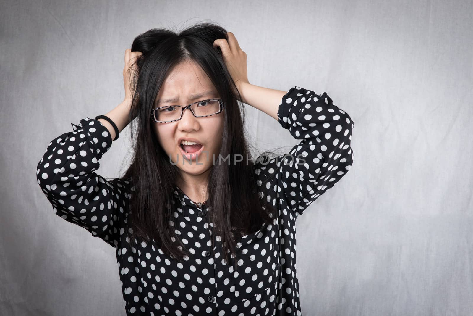 Girl pulling her hair in frustration by IVYPHOTOS