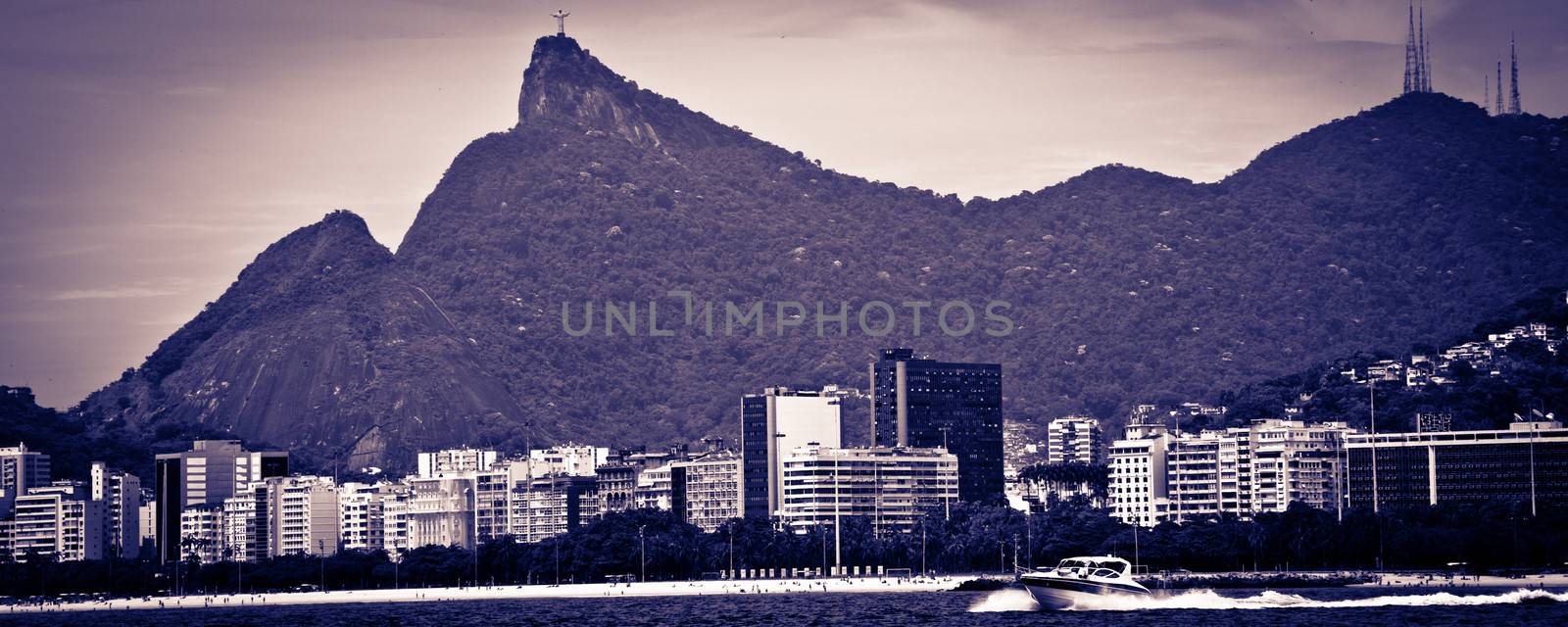 Panoramic view of Rio de Janeiro city coastline with Christ the Redeemer statue on mountains in background viewed from Guanbara bay, Brazil.
