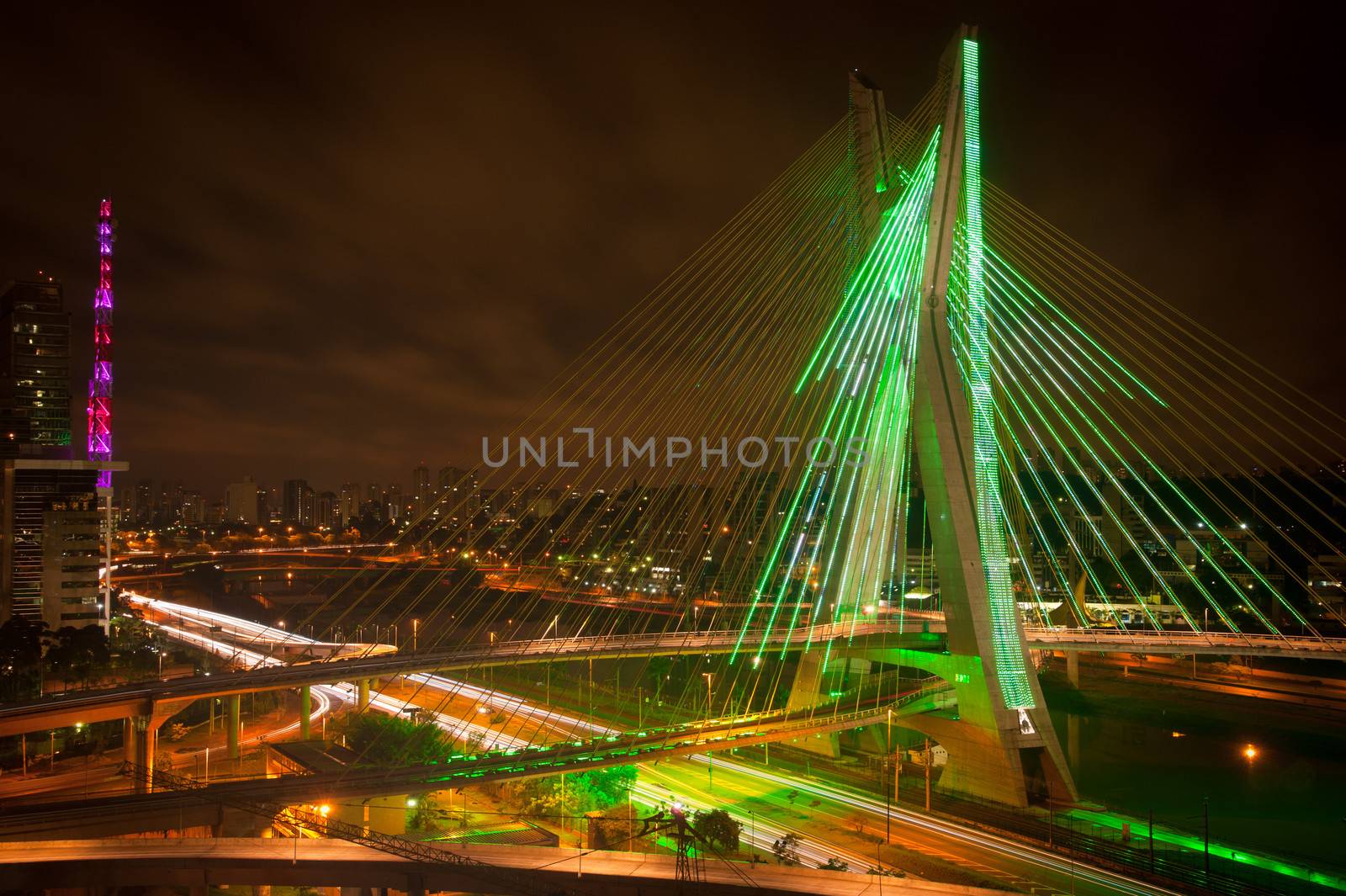 Scenic view of Octavio Frias de Oliveira bridge illuminated at night over Pinheiros river in Sao Paulo, Brazil.