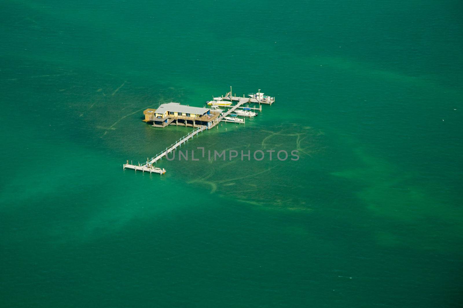 Stilt house and pier in the ocean by CelsoDiniz