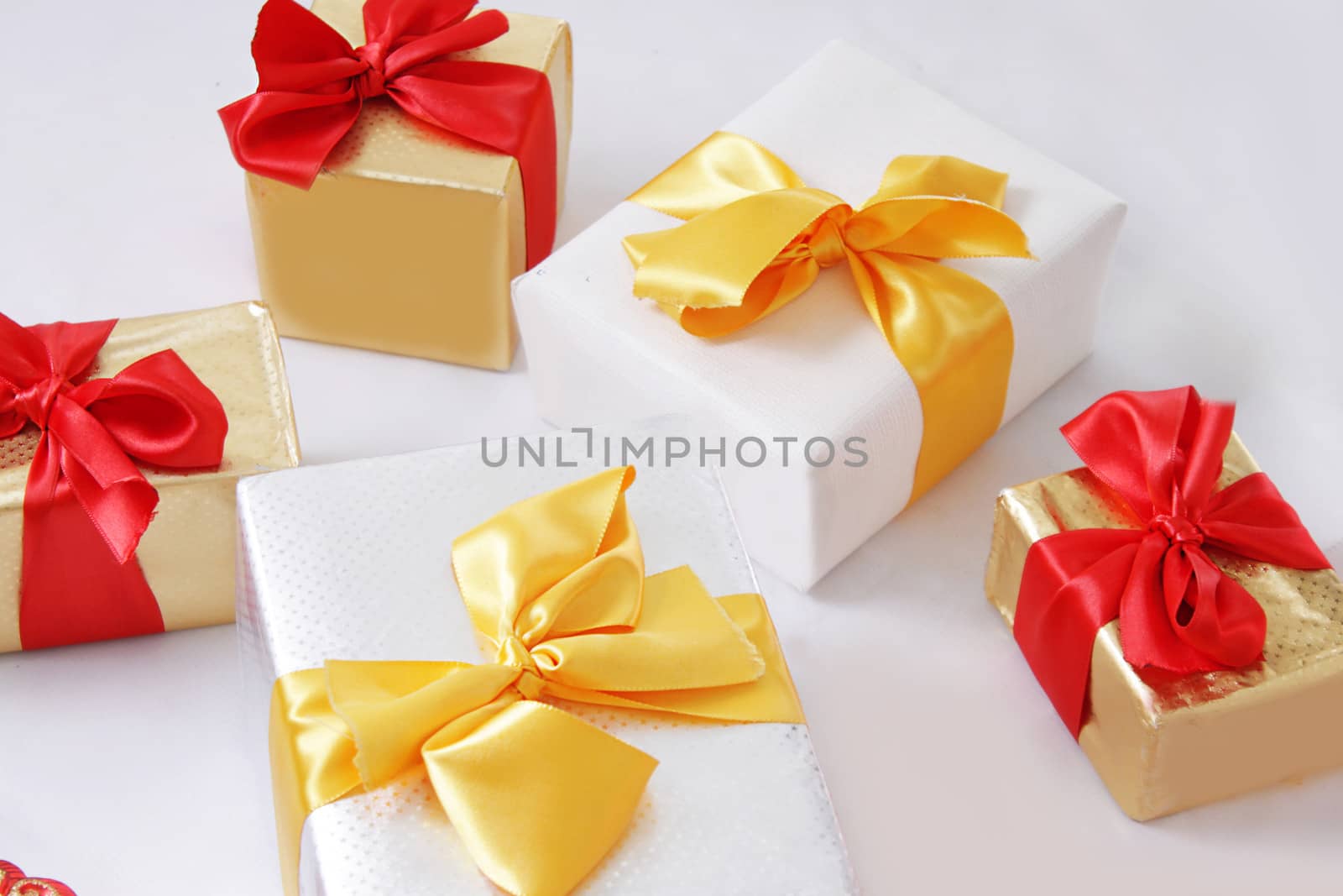 Gift boxes with golden and red ribbon over white