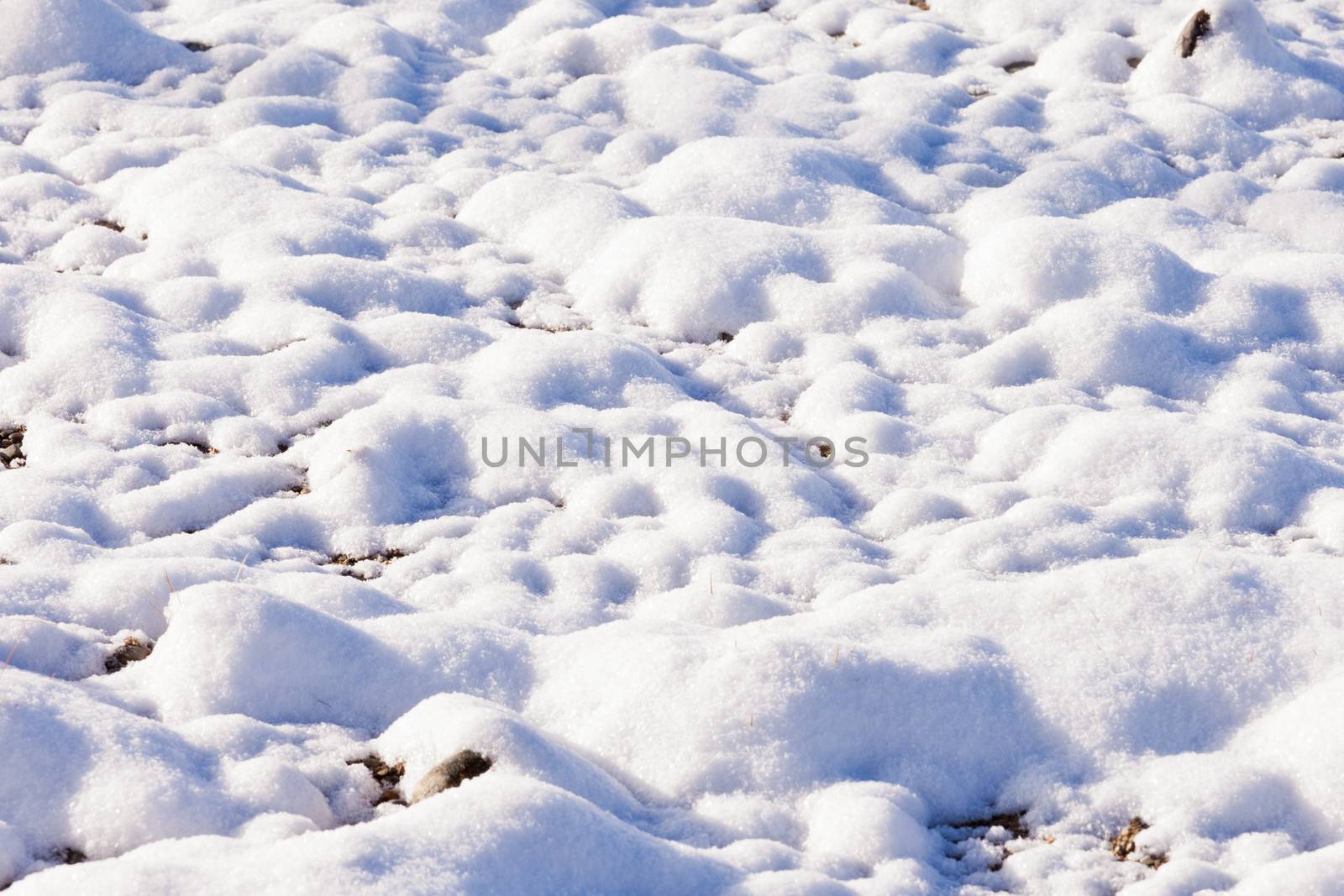 Thawing fresh snow covers cobble stone gravel by PiLens