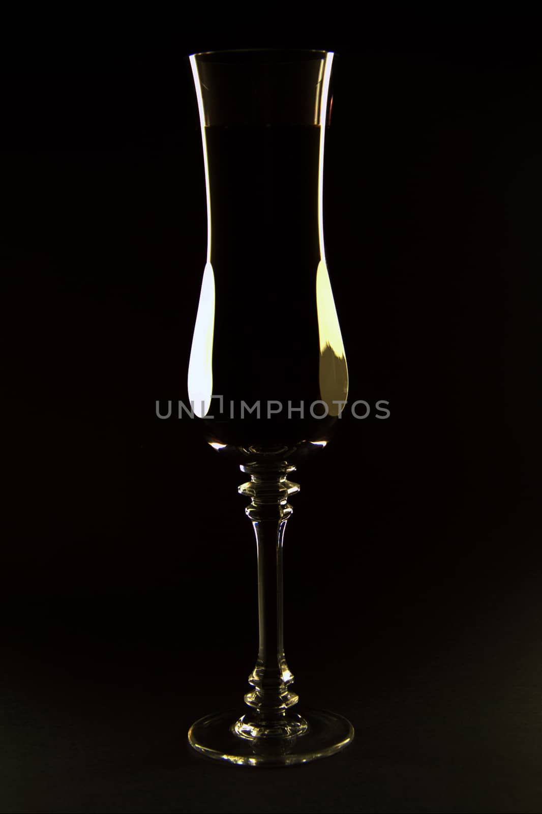 Natural silhouette from cast light on the edges of a tall champagne glass or flute.