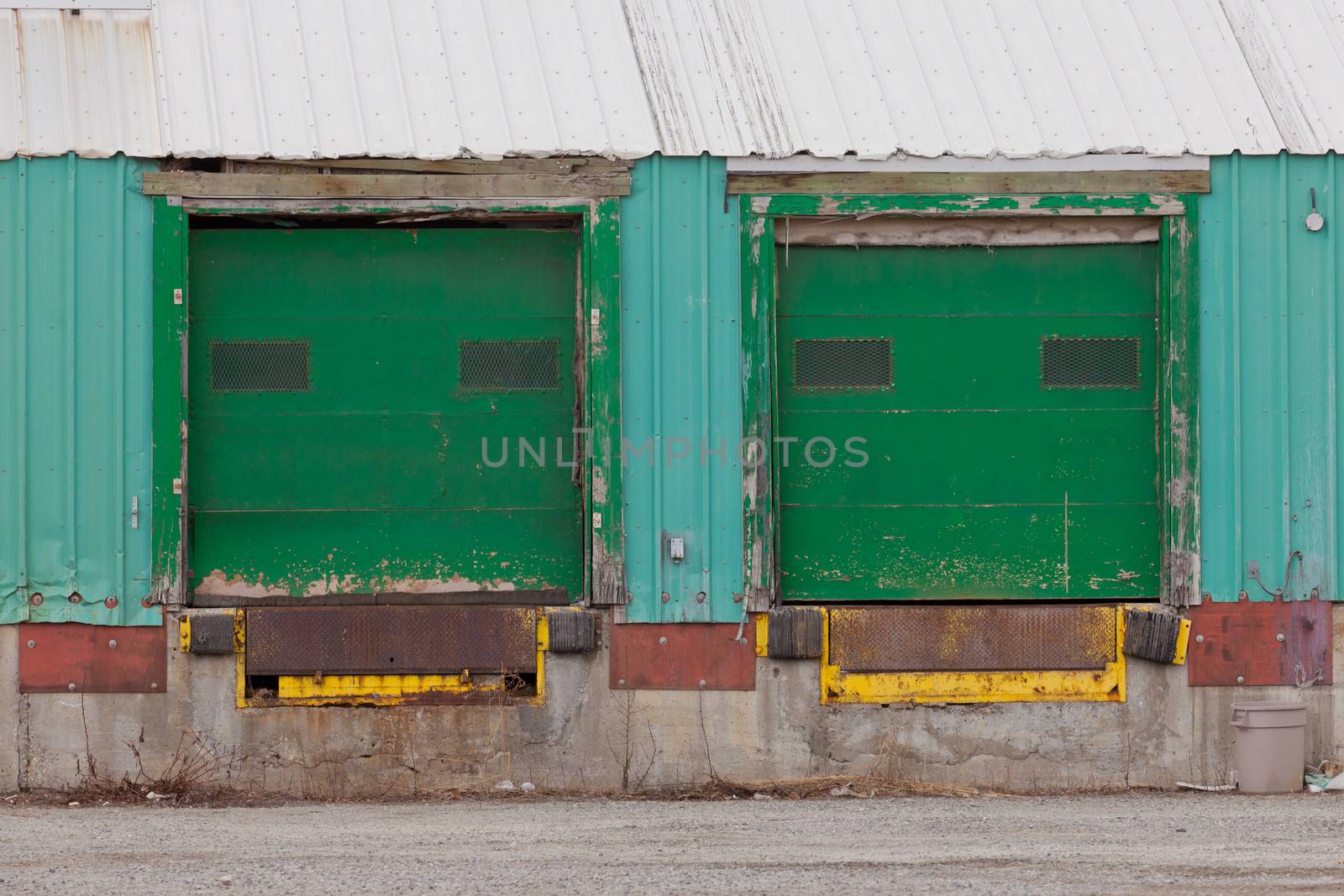 Two green painted shuttered doors for loading in a prefabricated metal clad warehouse building