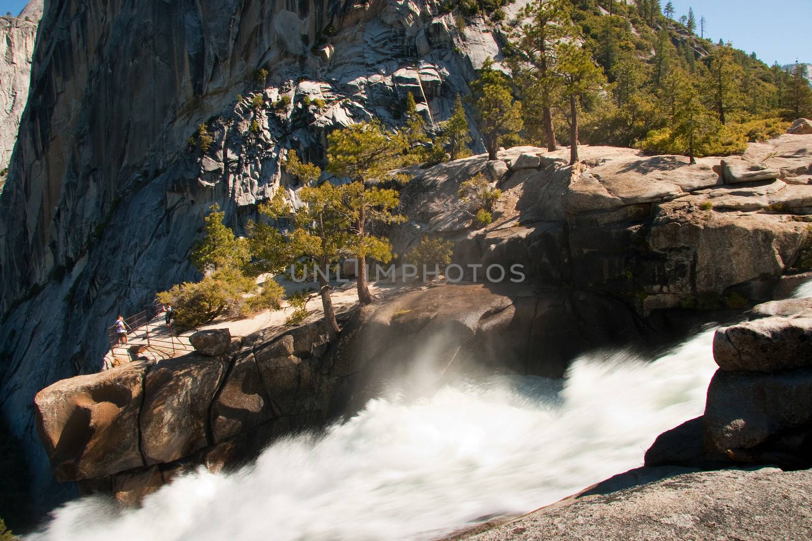 Scenic view of waterfall in Yosemite National Park with Half Dome rock formations in background, California, U.S.A.