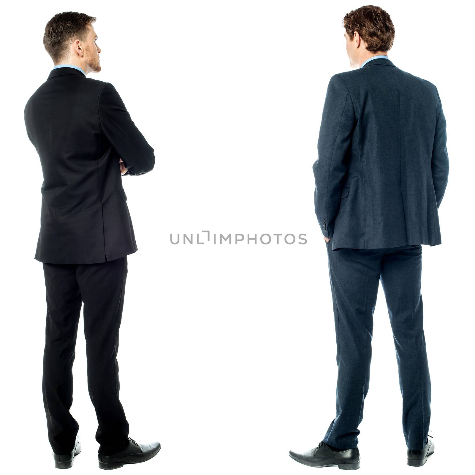 Two businessmen facing towards the wall
