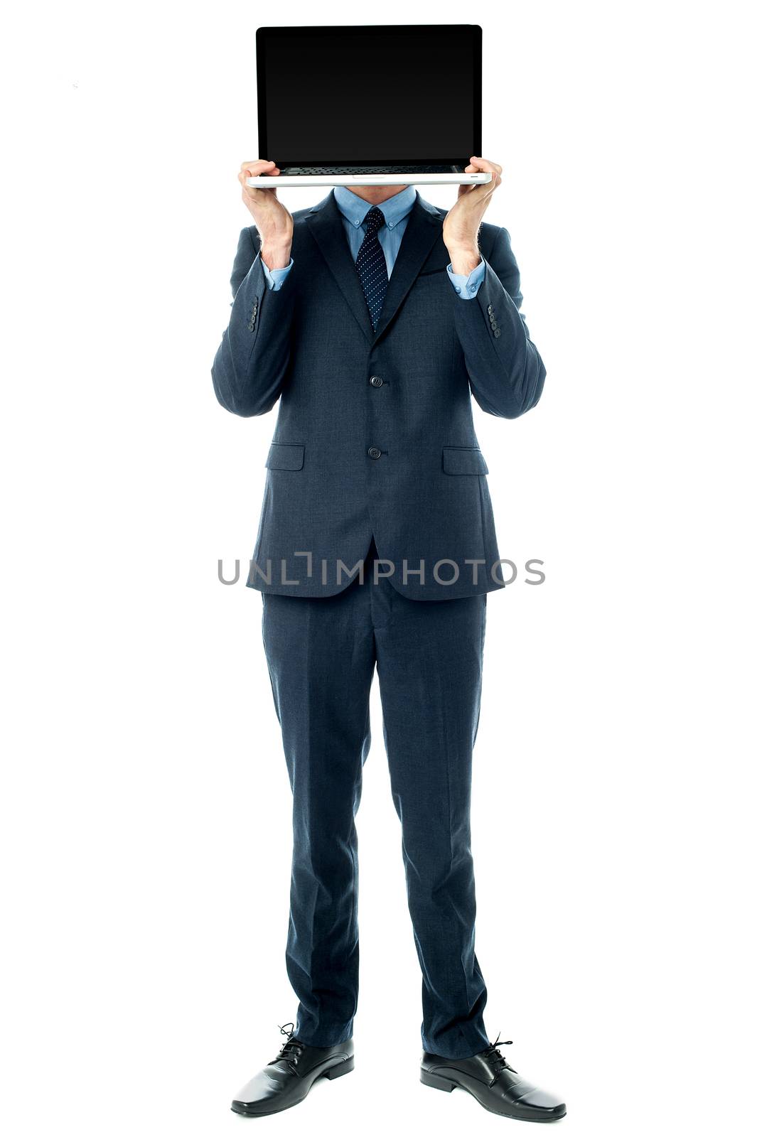 Businessman covering his face with laptop by stockyimages