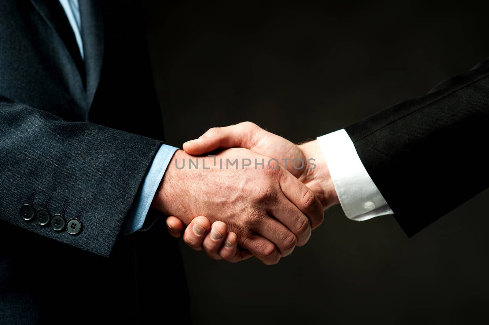 Business handshake on black background by stockyimages