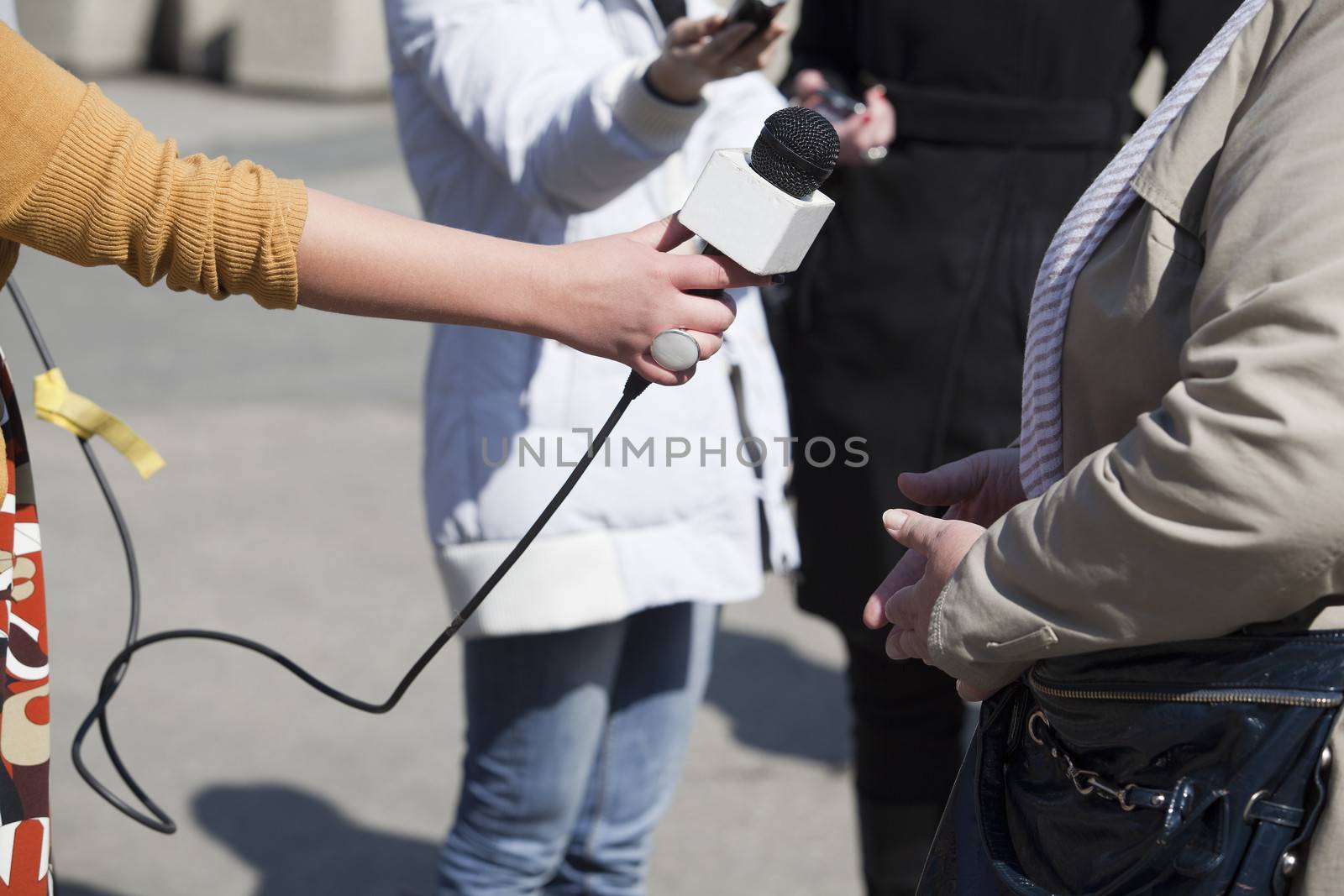 A journalist is making a interview with a microphone