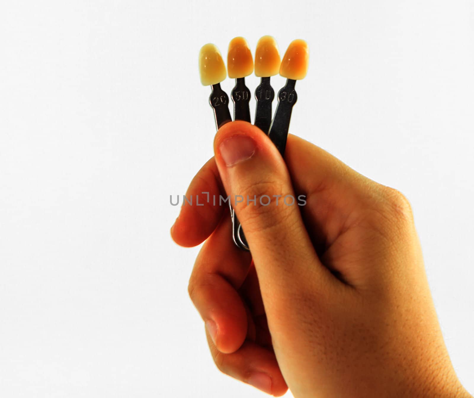 woman hand with shade guide teeth isolated on white background