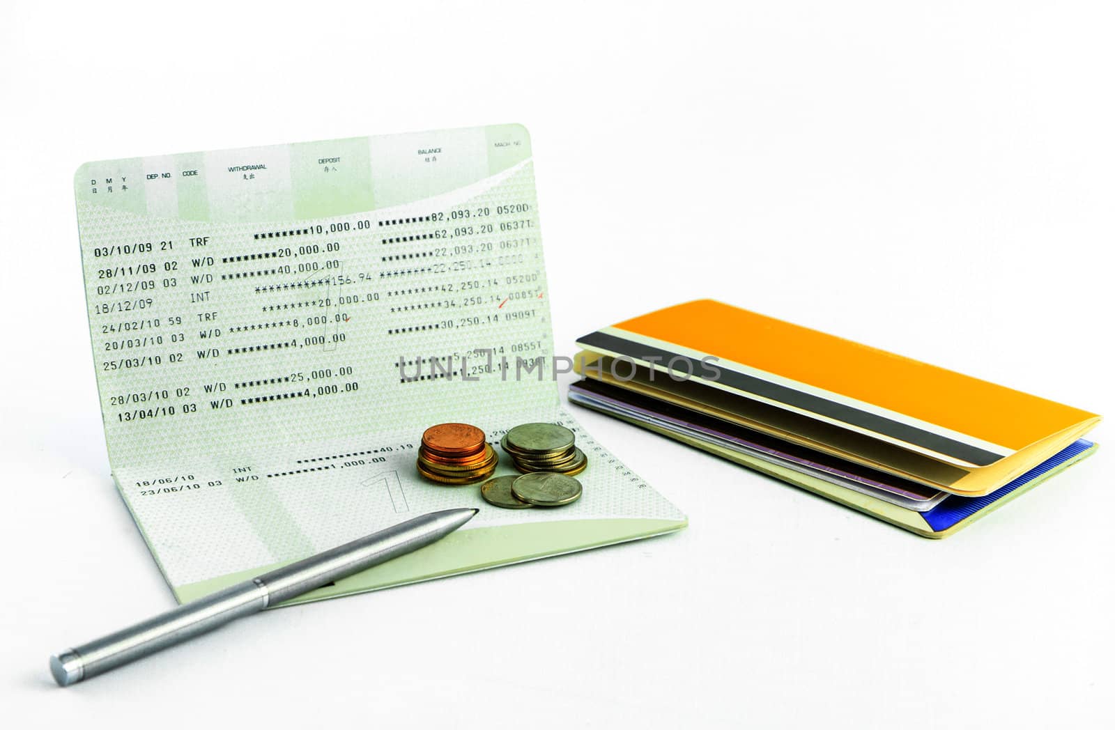 Coins and pen on account passbook isolate on white background