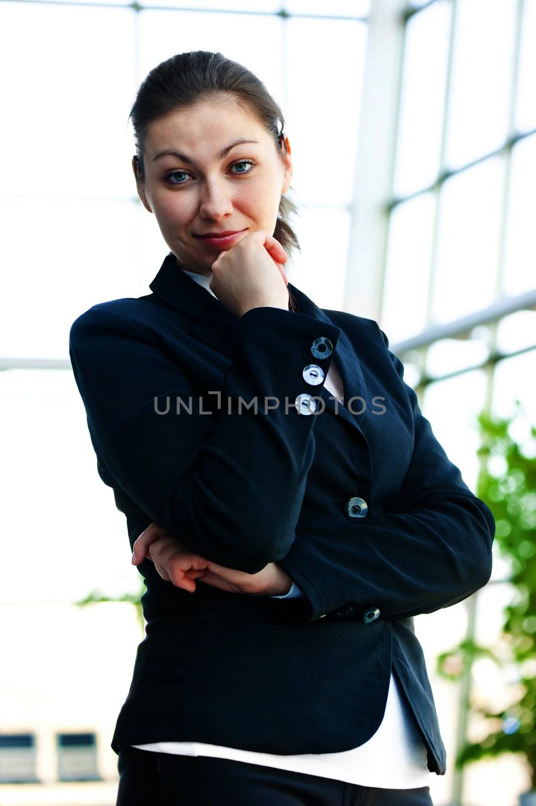 Portrait of successful business woman smiling on the background of a blurred office interior by kosmsos111