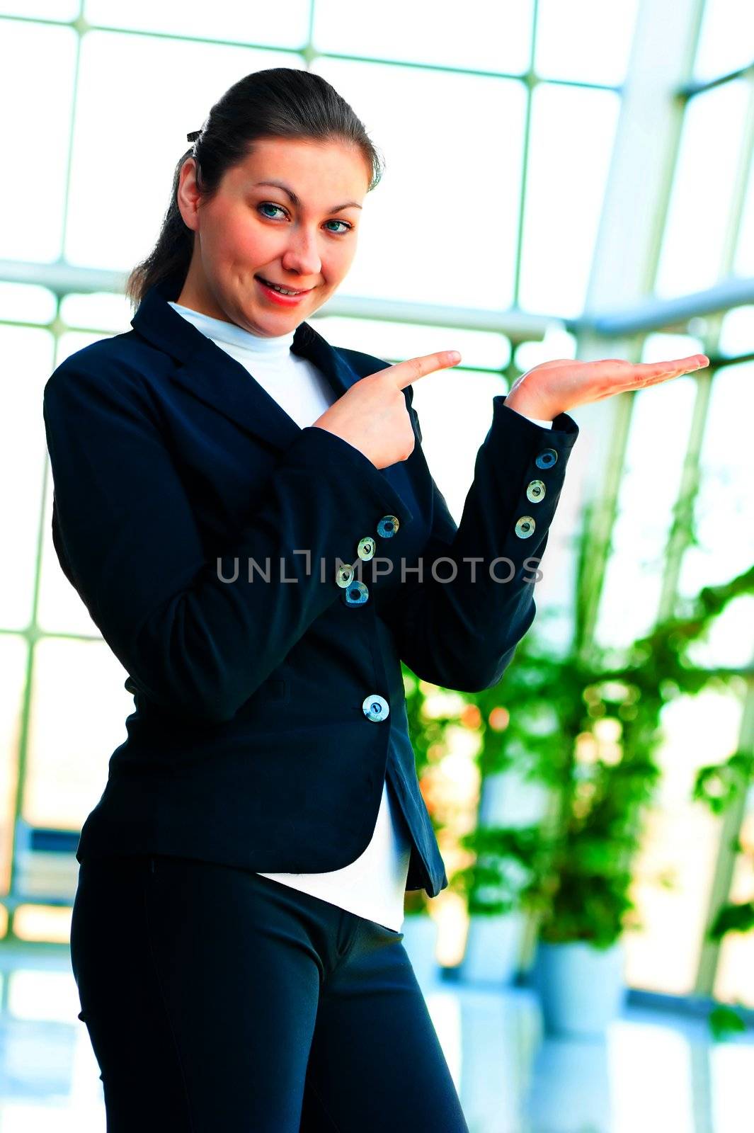 Girl in a business suit holding something on the palm and finger pointing to it