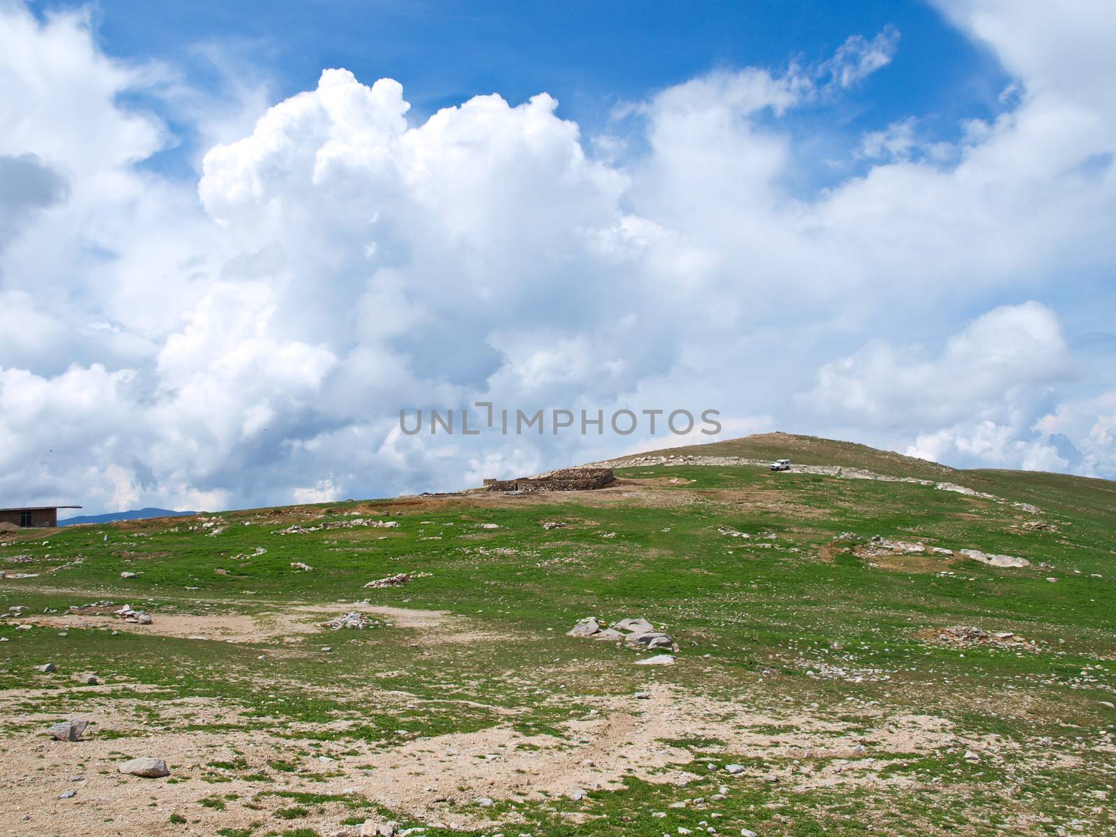 Green grass hill and cloudy blue sky by gururugu