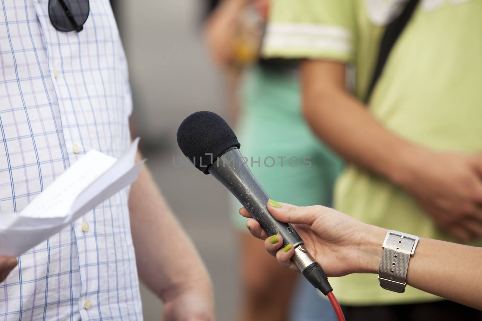 A journalist is making a interview with a microphone