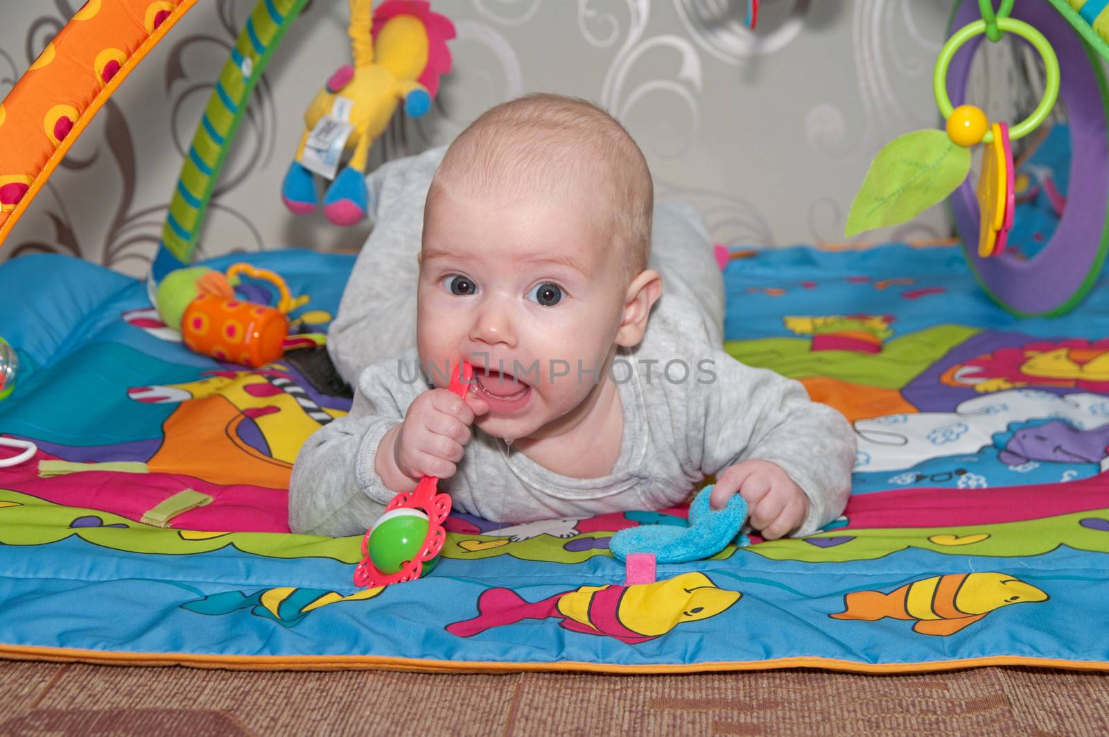 Portrait of the smiling baby with rattle.