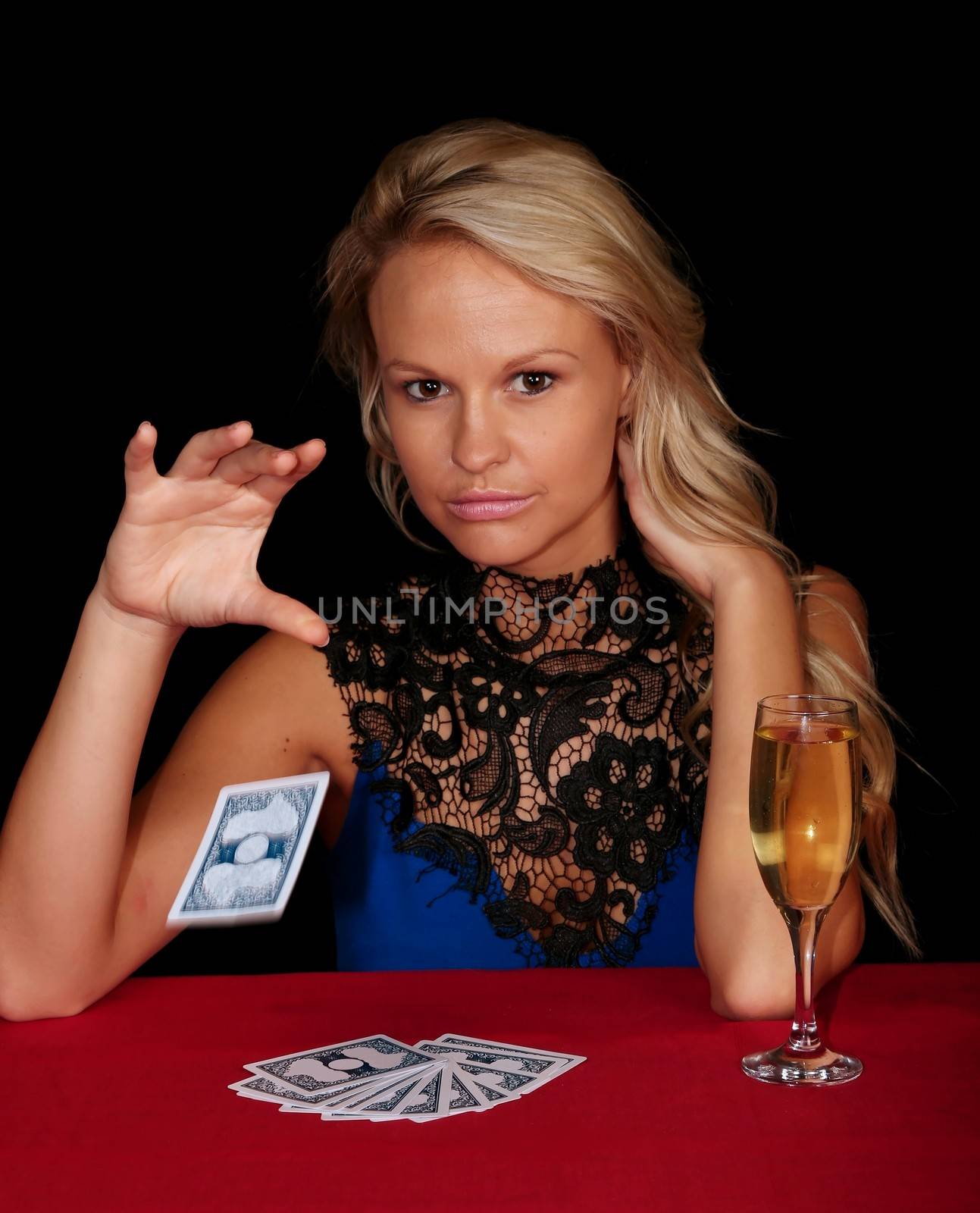 Lovely lady poker player dropping a card onto the table