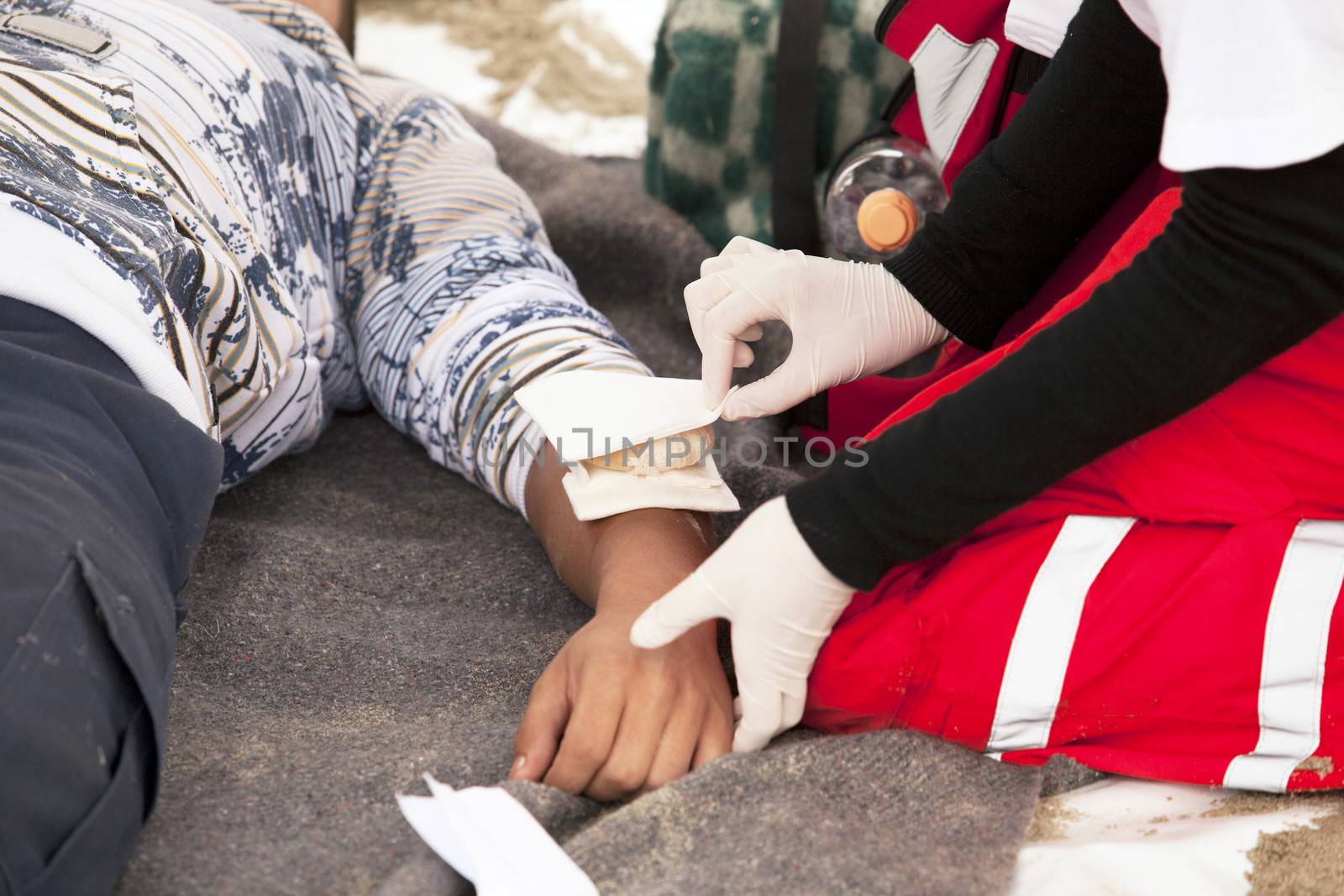 Paramedic applying bandage to arm of an accident victim