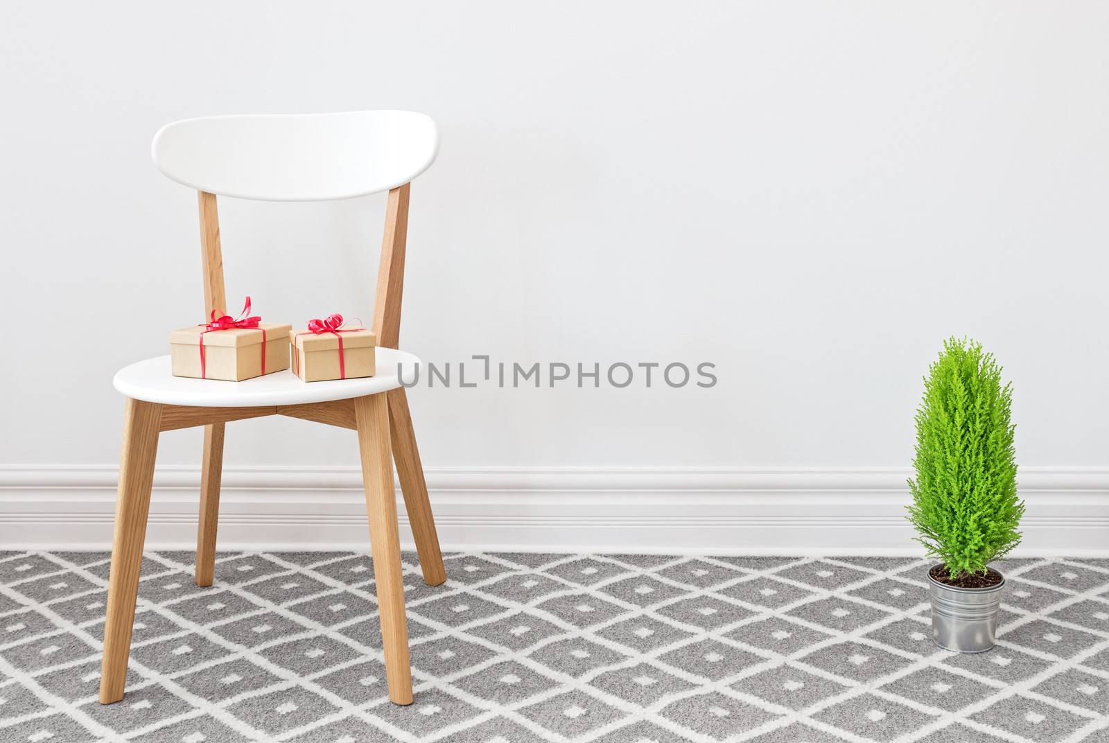 Presents on an elegant white chair, and little green cypress tree.